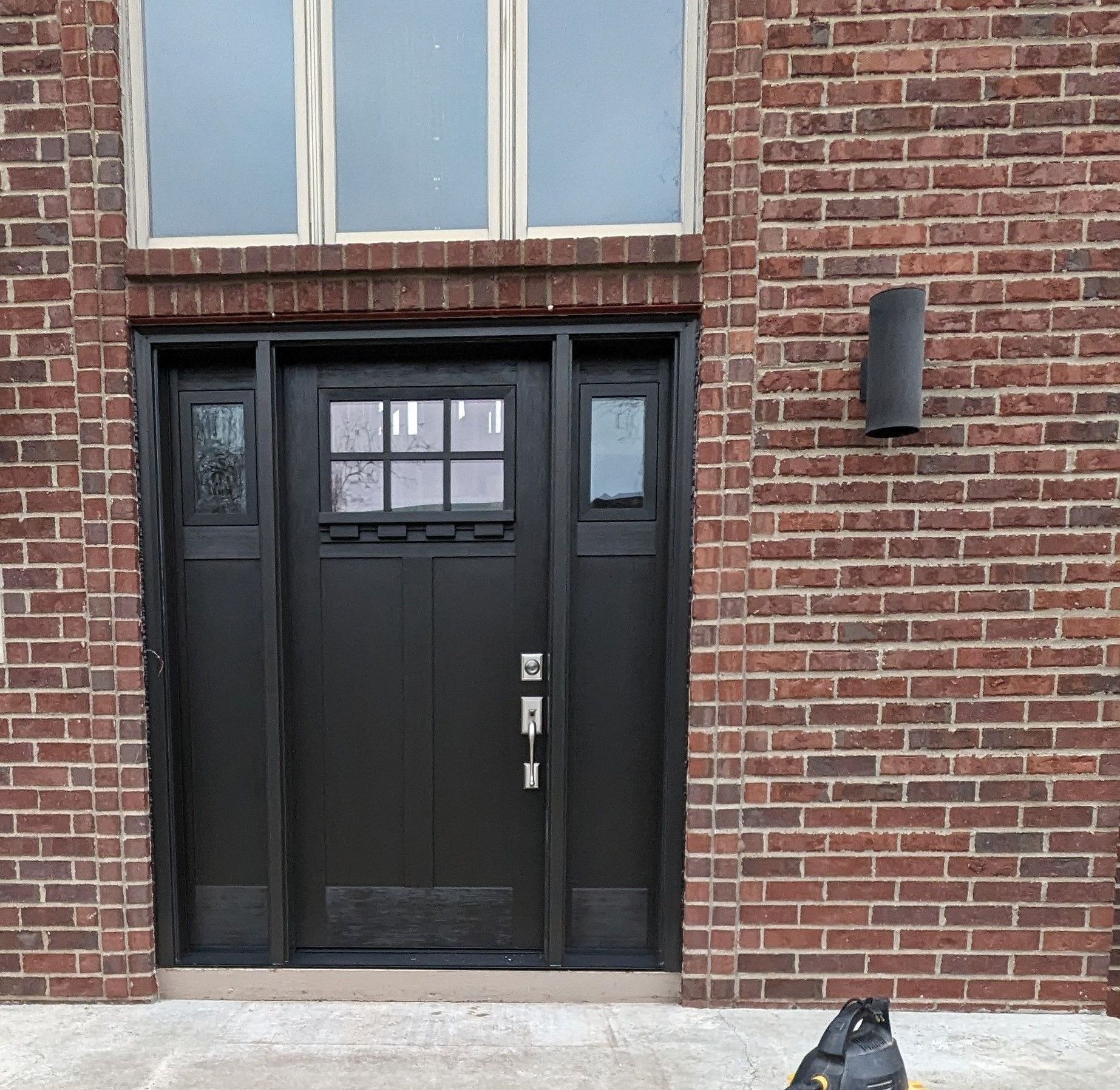 A Black Door Is on The Side of A Brick Building — Carver, MN — TJ Exteriors Inc.