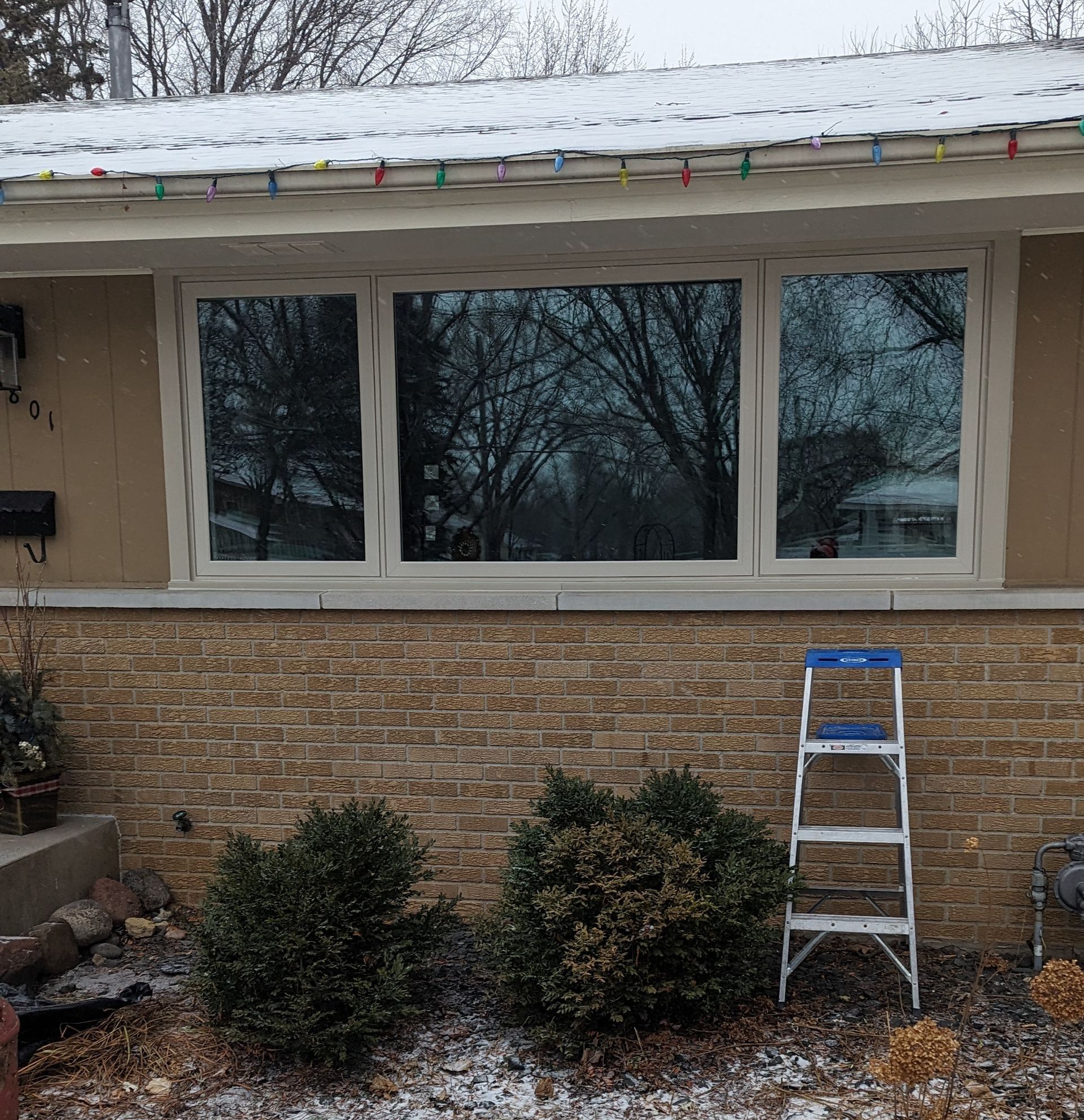 A Ladder Is Sitting in Front of A House with Snow on The Ground — Carver, MN — TJ Exteriors Inc.