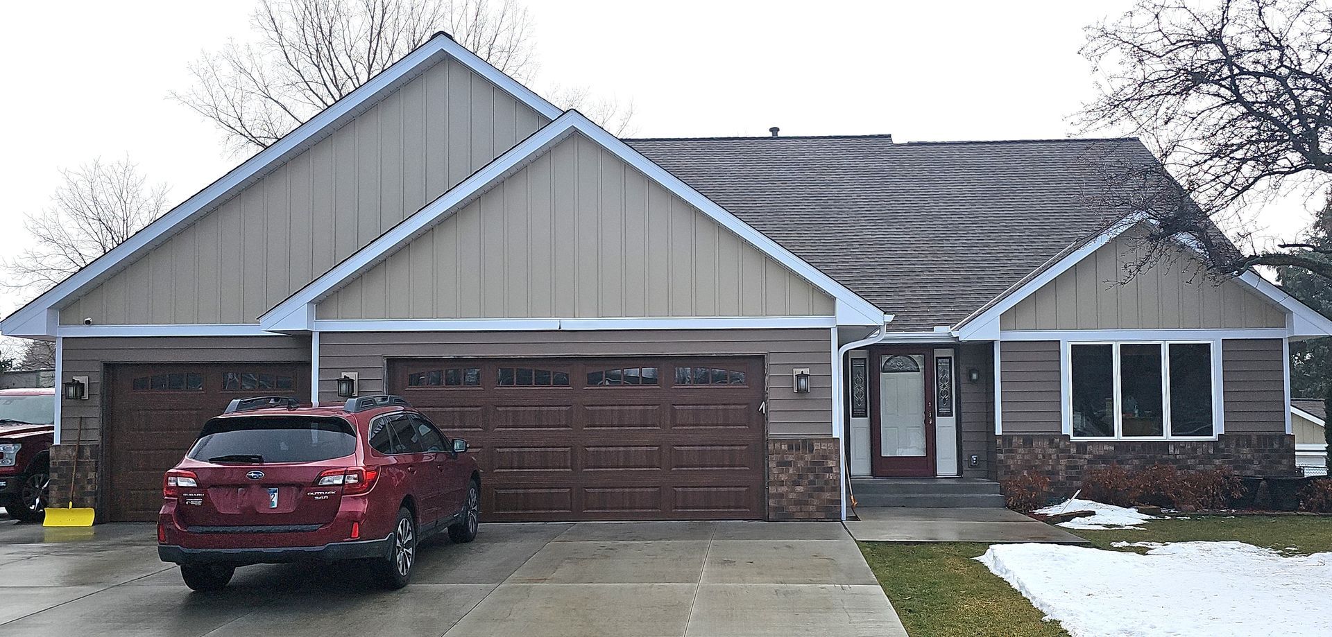 A red car is parked in front of a house.