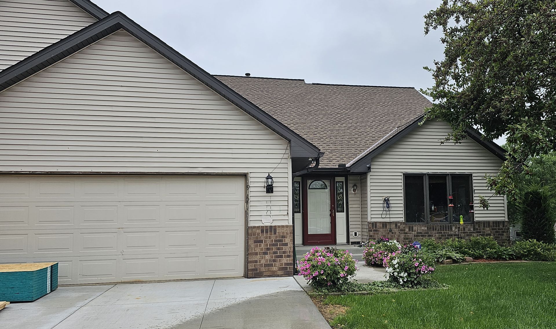 A white house with a black roof and a garage door