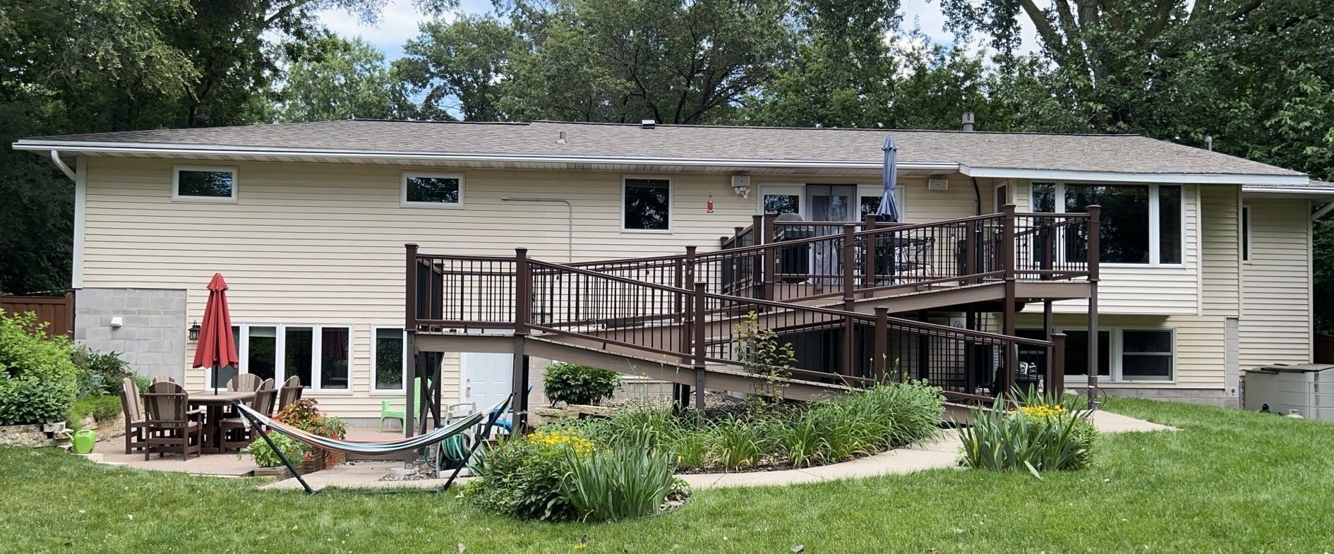 A large house with a large deck in the backyard.