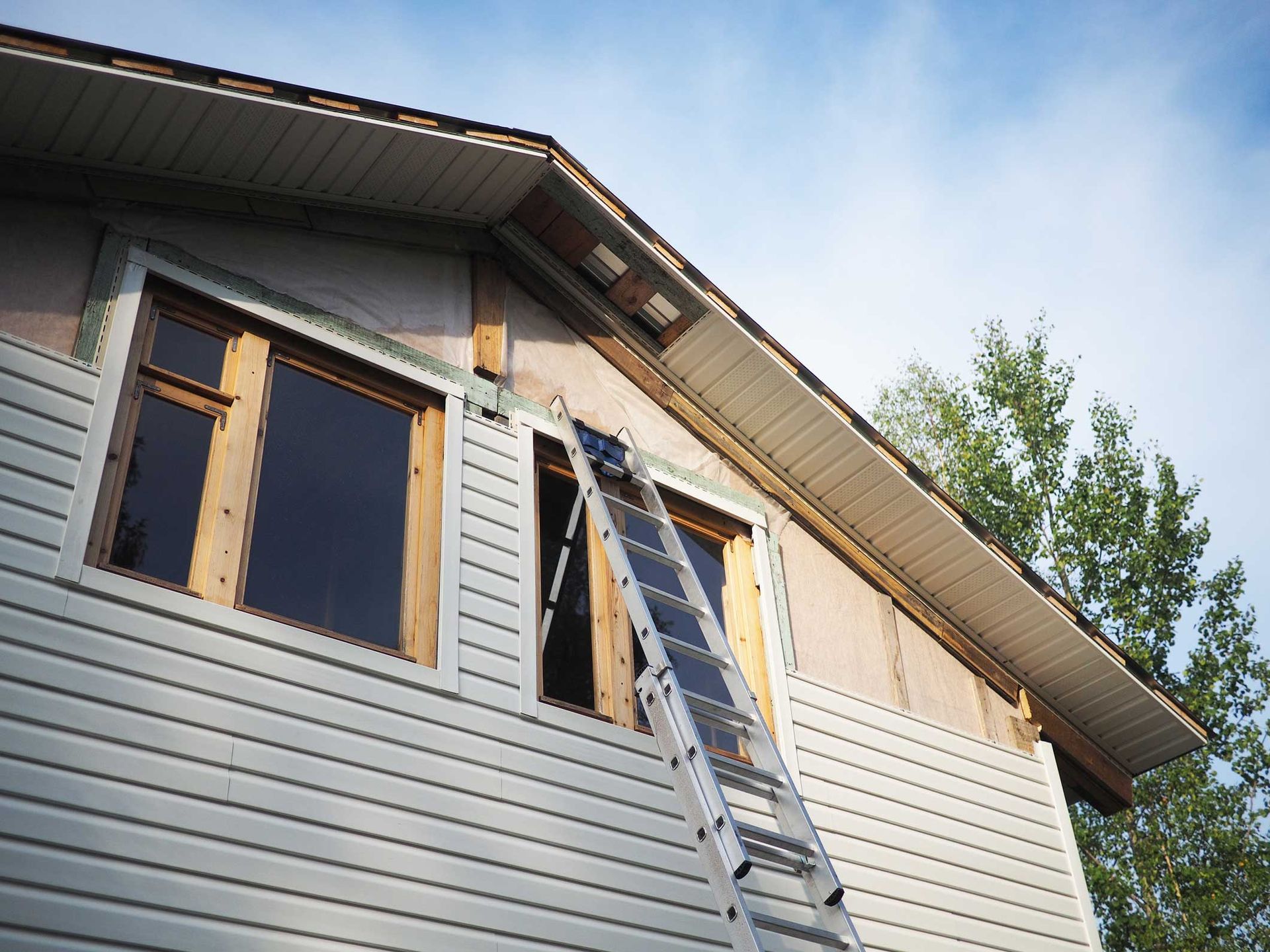 A house exterior undergoing siding installation with a metal. A house exterior undergoing siding installation with a metal.