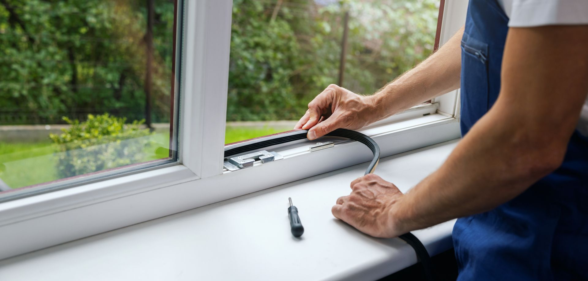 worker installing sealing tape on a window frame