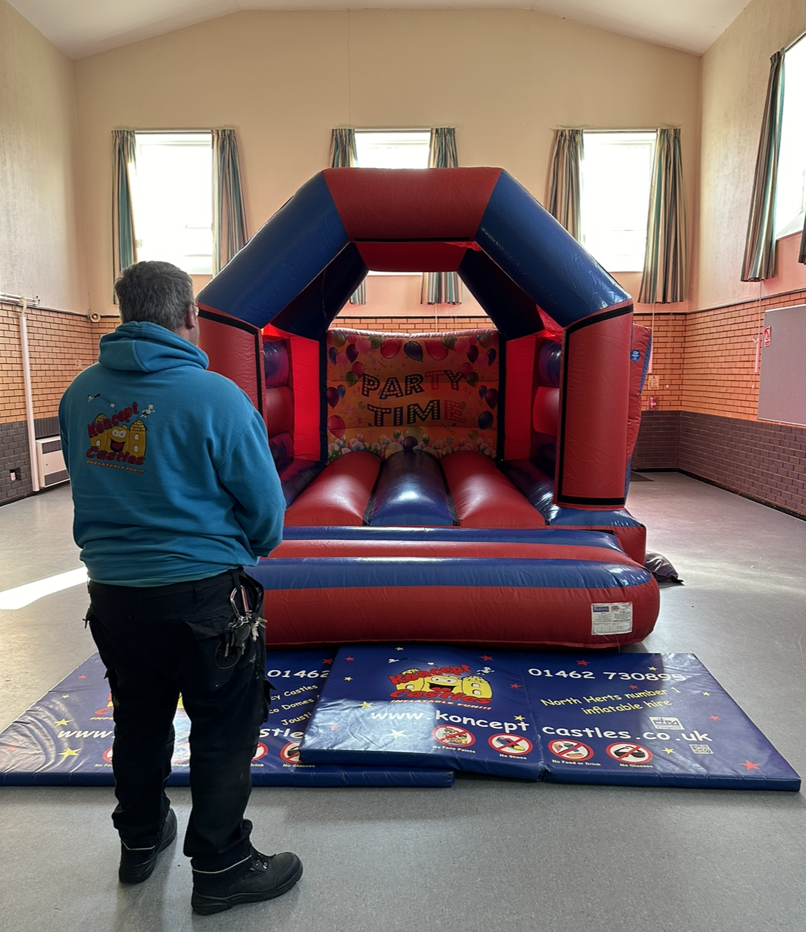 Koncept castle supervising the 12ft red and blue bouncy castle for a event. 