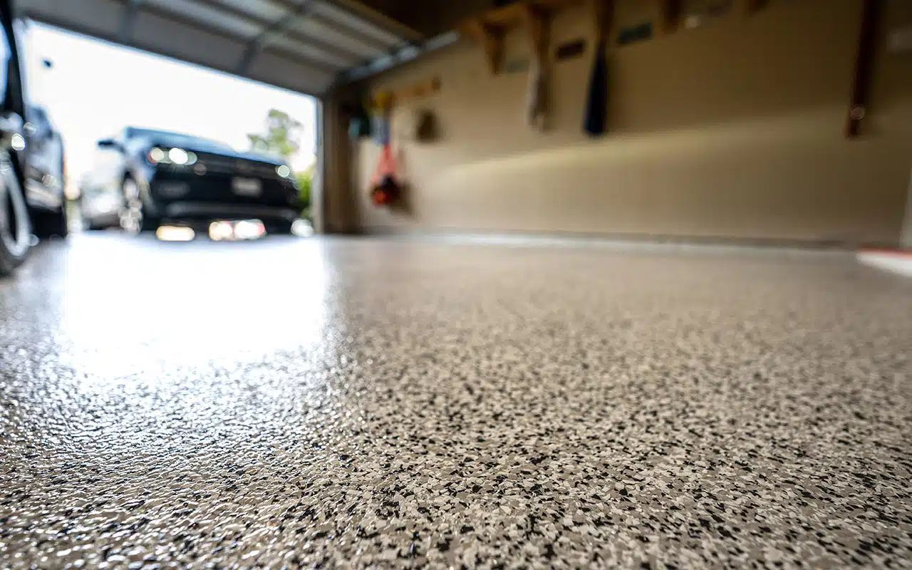 A car is parked in a garage with a concrete floor.