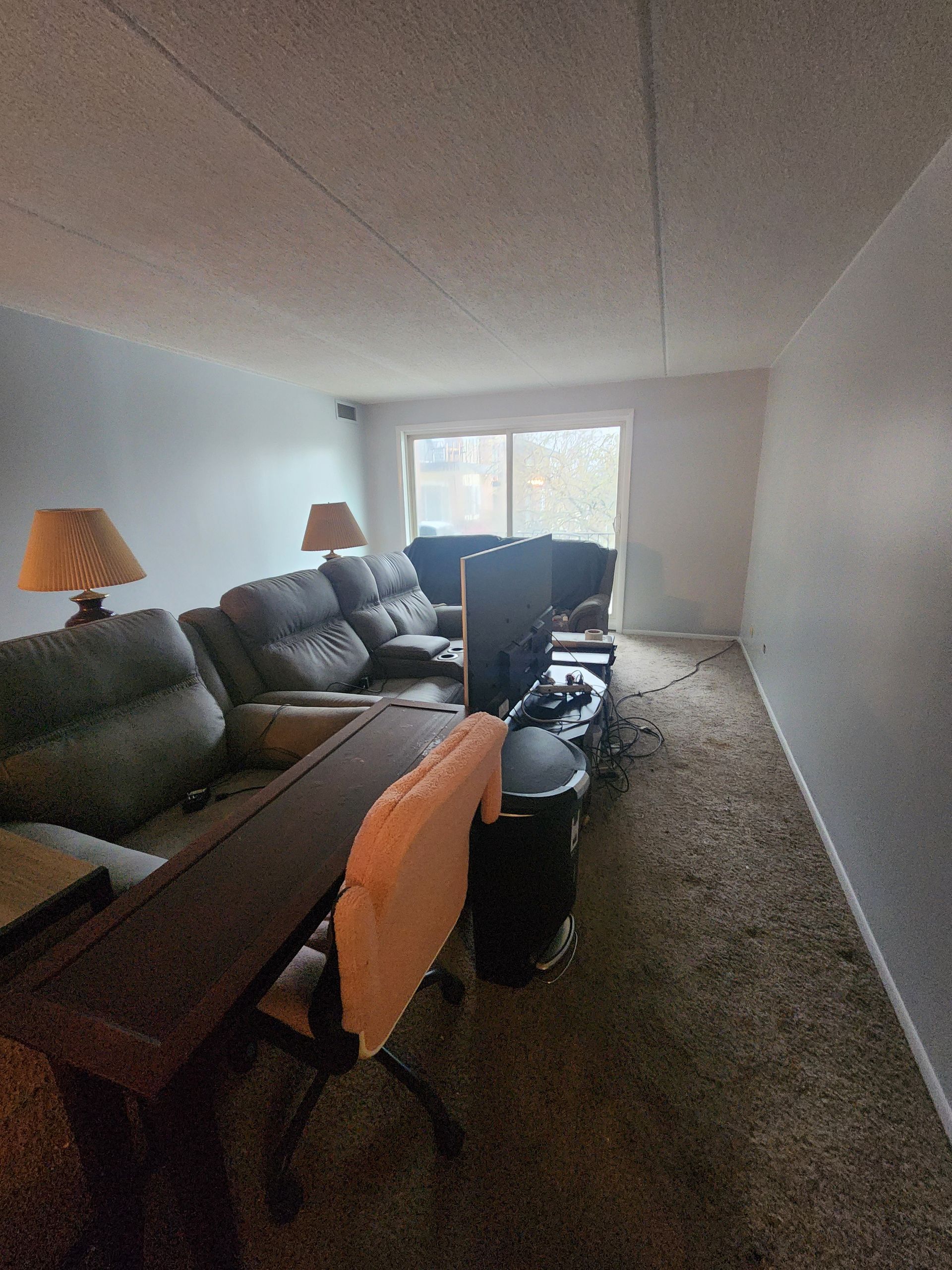 A living room with a couch , chair , desk , and television.