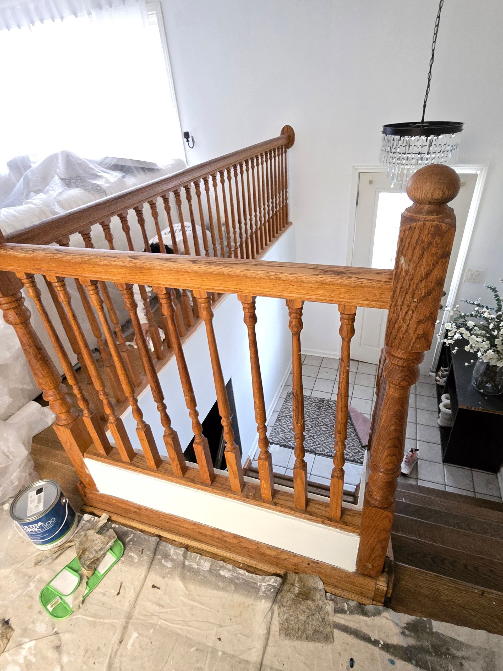 Wooden staircase with white accents. Balusters, handrails, and a rounded newel post are visible.