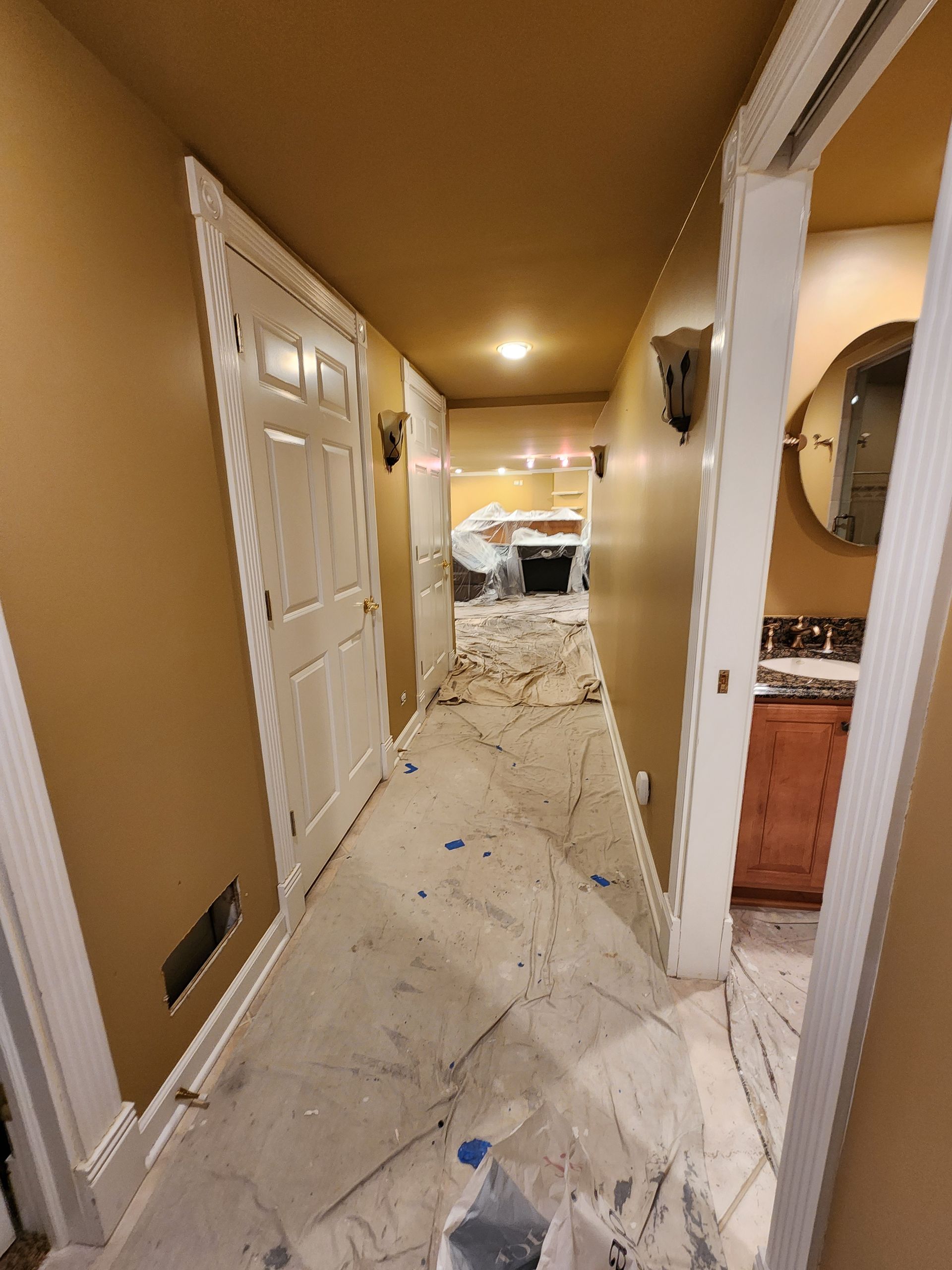 A hallway in a house that is being painted.