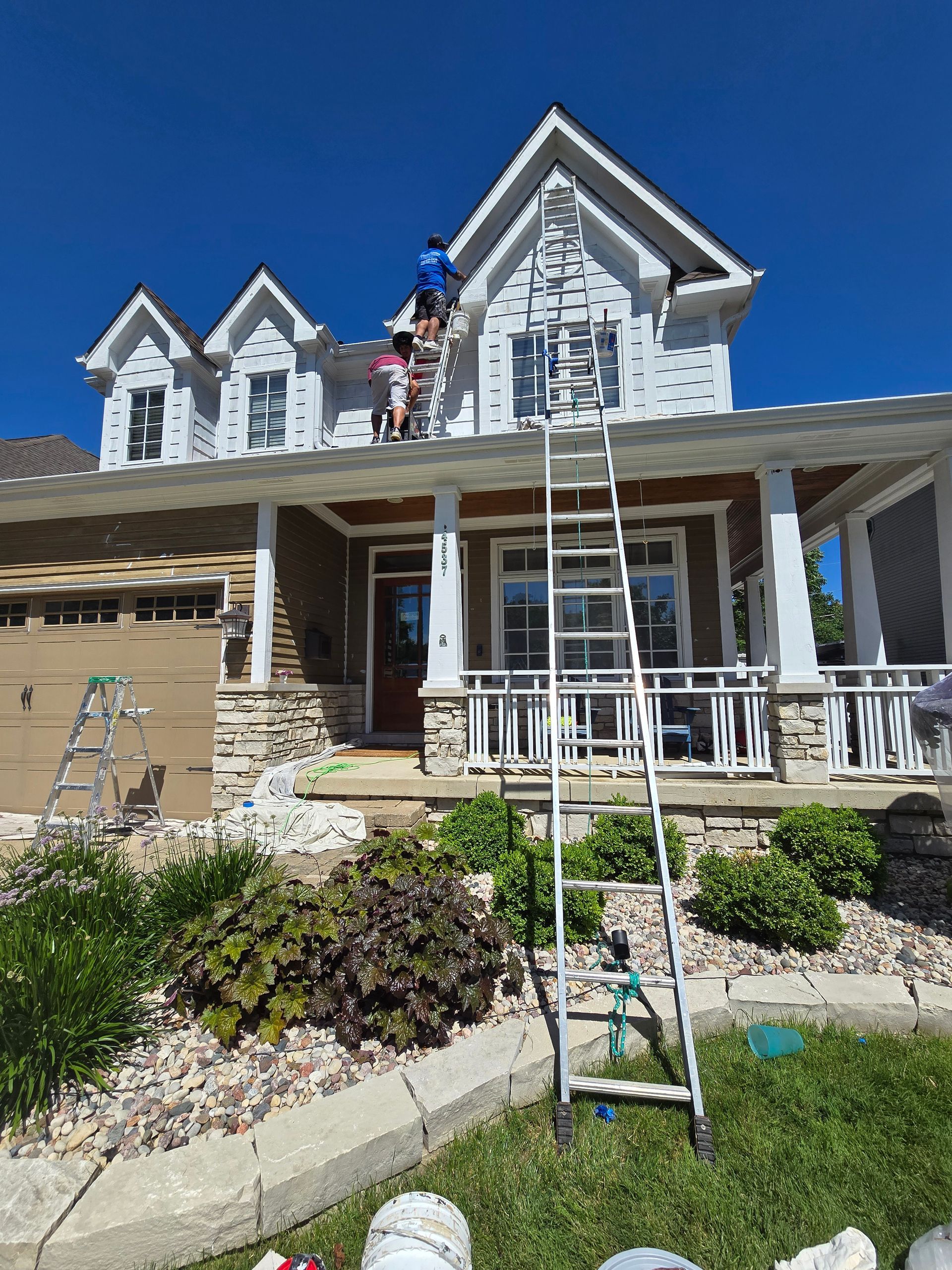 A group of people are painting the side of a house.