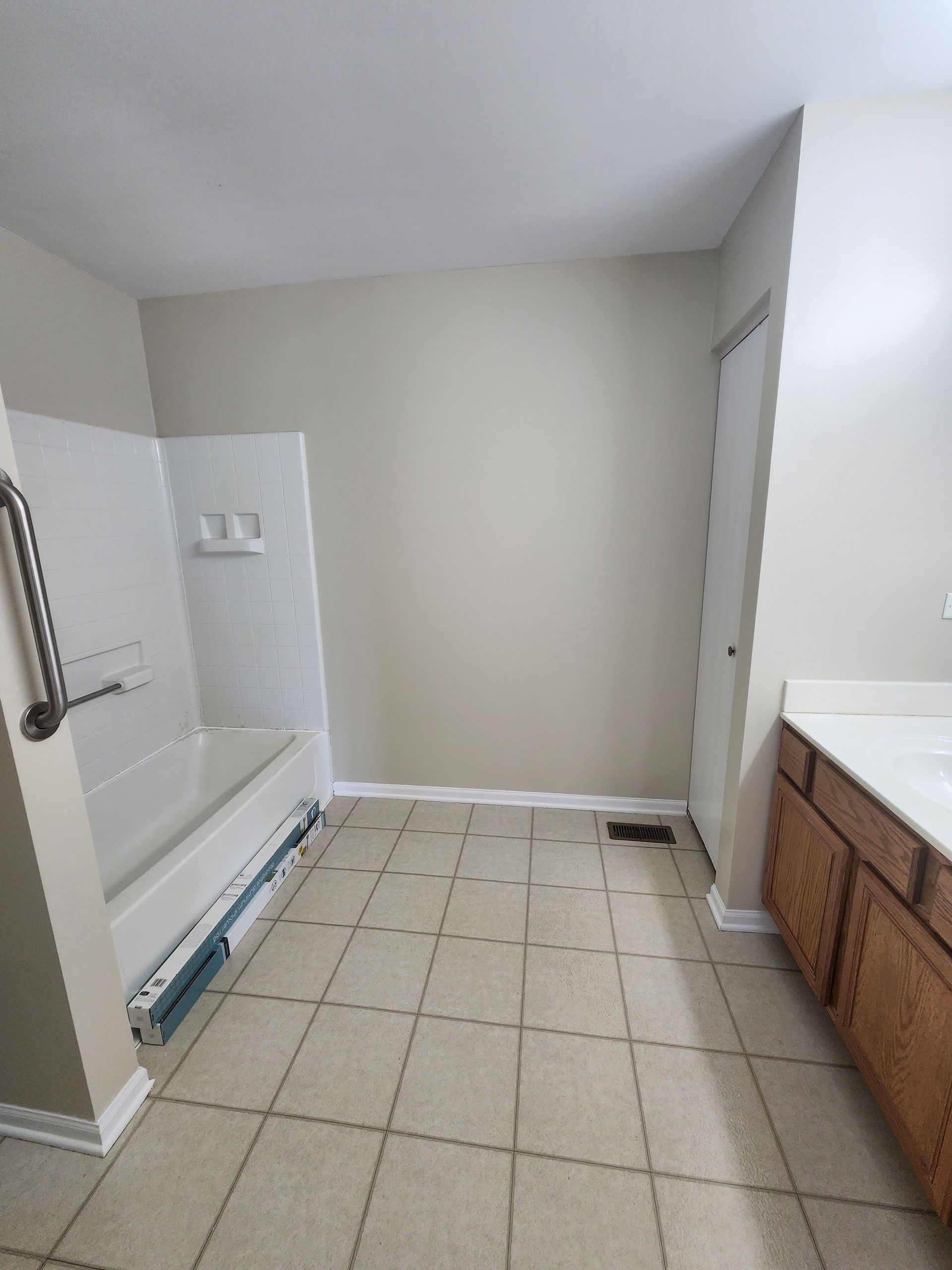 A bathroom with a tub , sink , and shower.