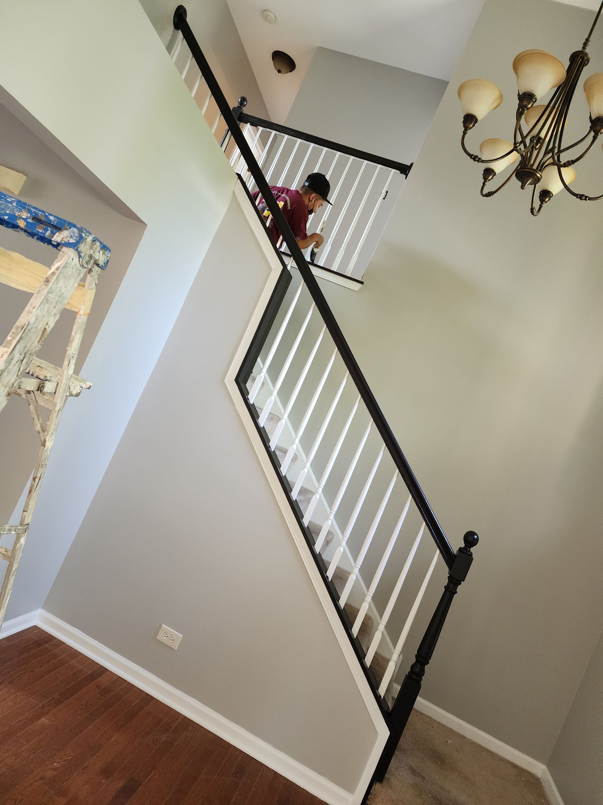 A man is painting the stairs in a house