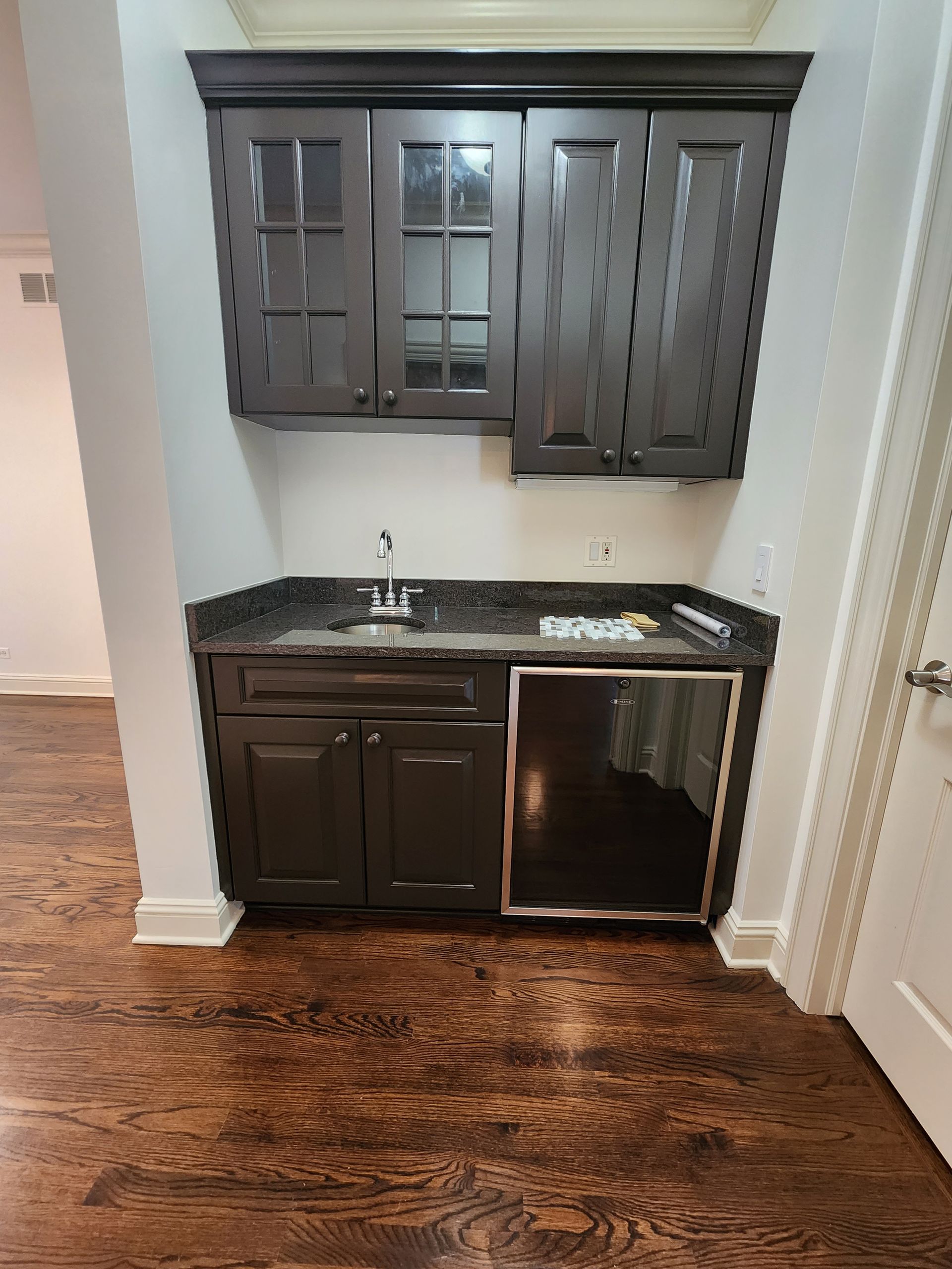 A kitchen with a sink , refrigerator , and cabinets.
