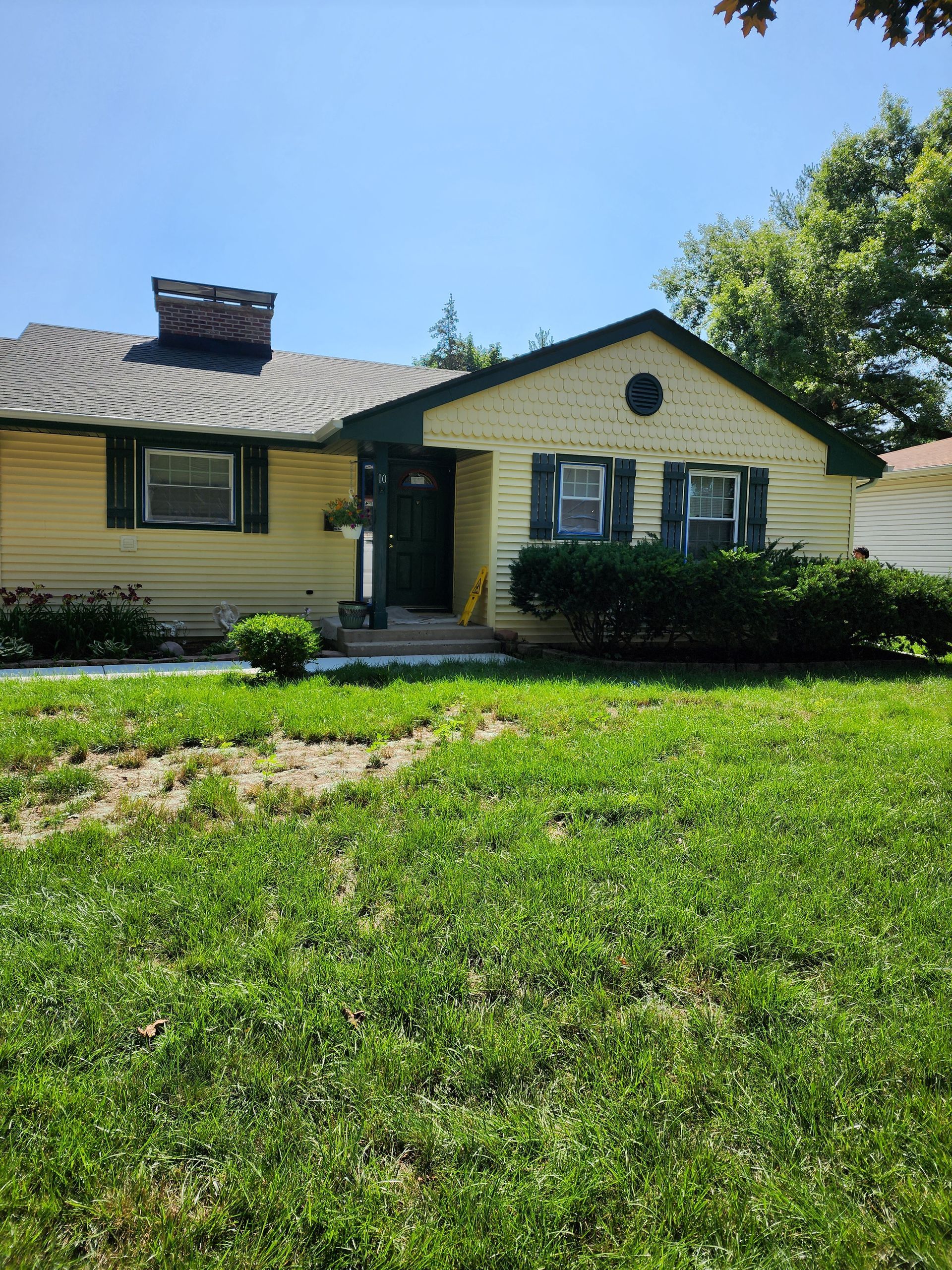 A house with a lush green lawn in front of it