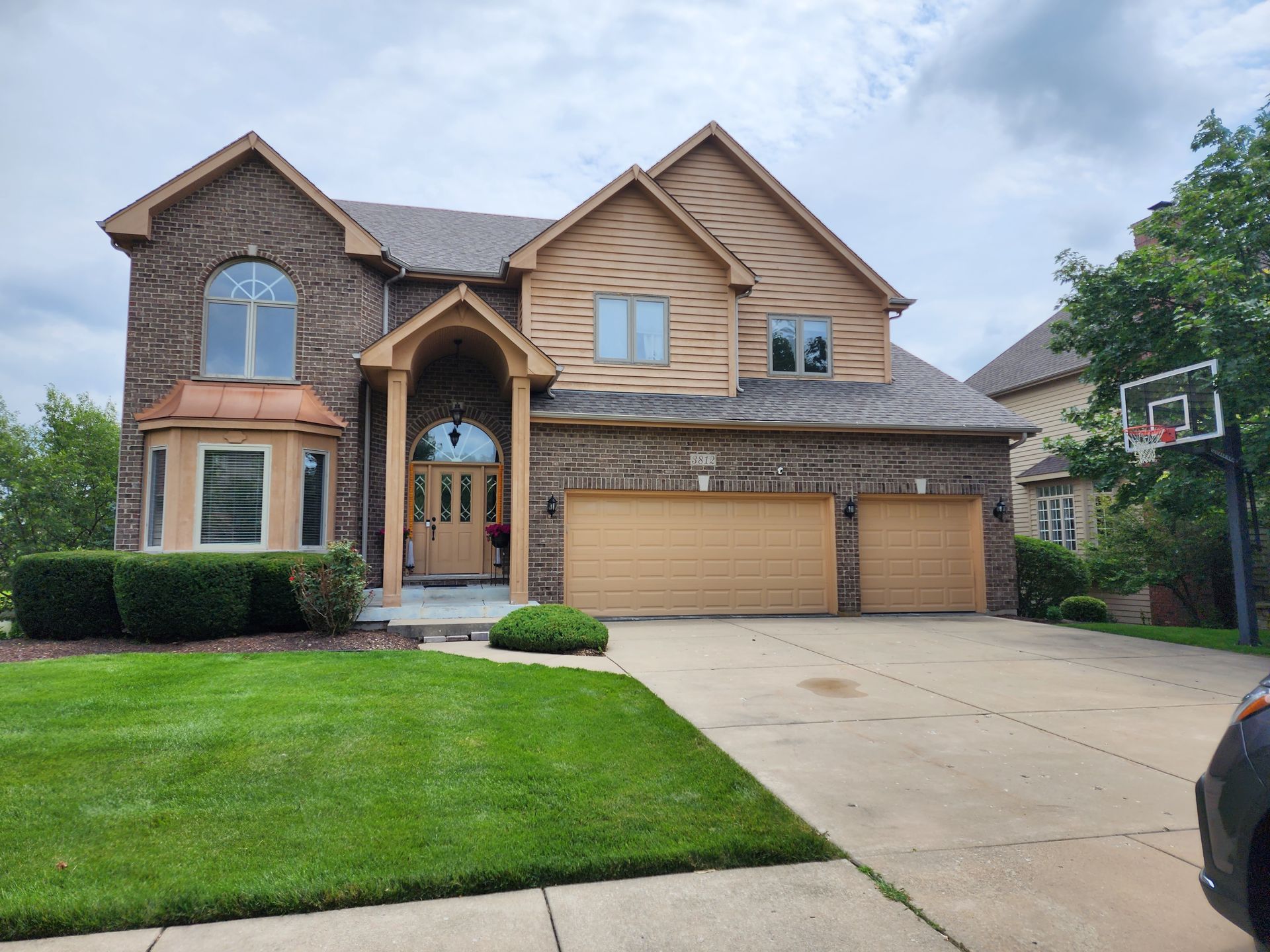 A large house with a basketball hoop in front of it.