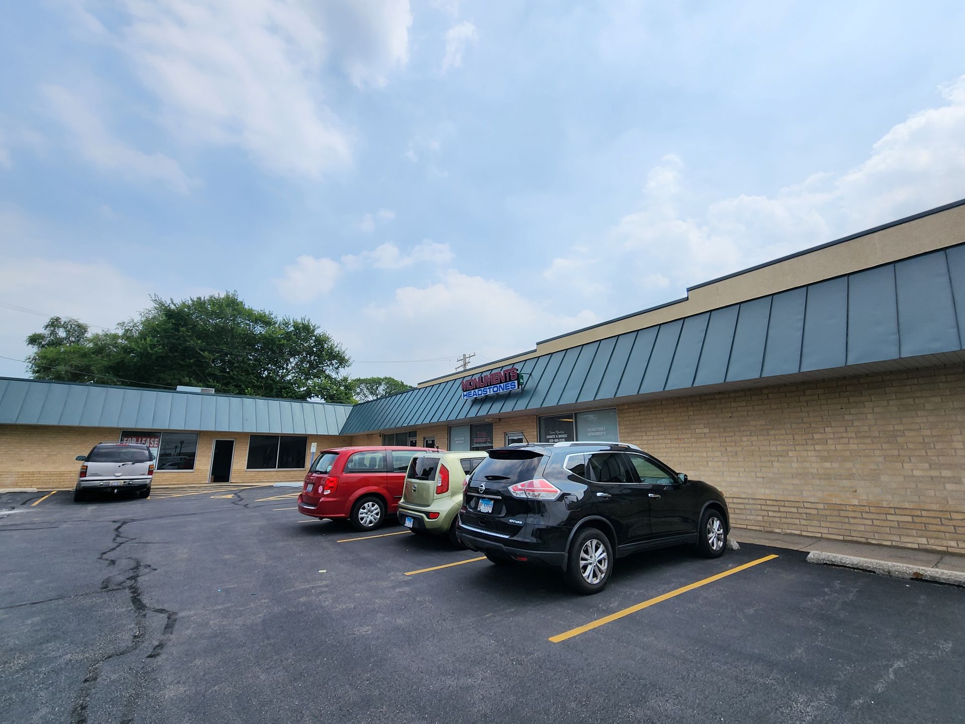 A row of cars are parked in front of a building.