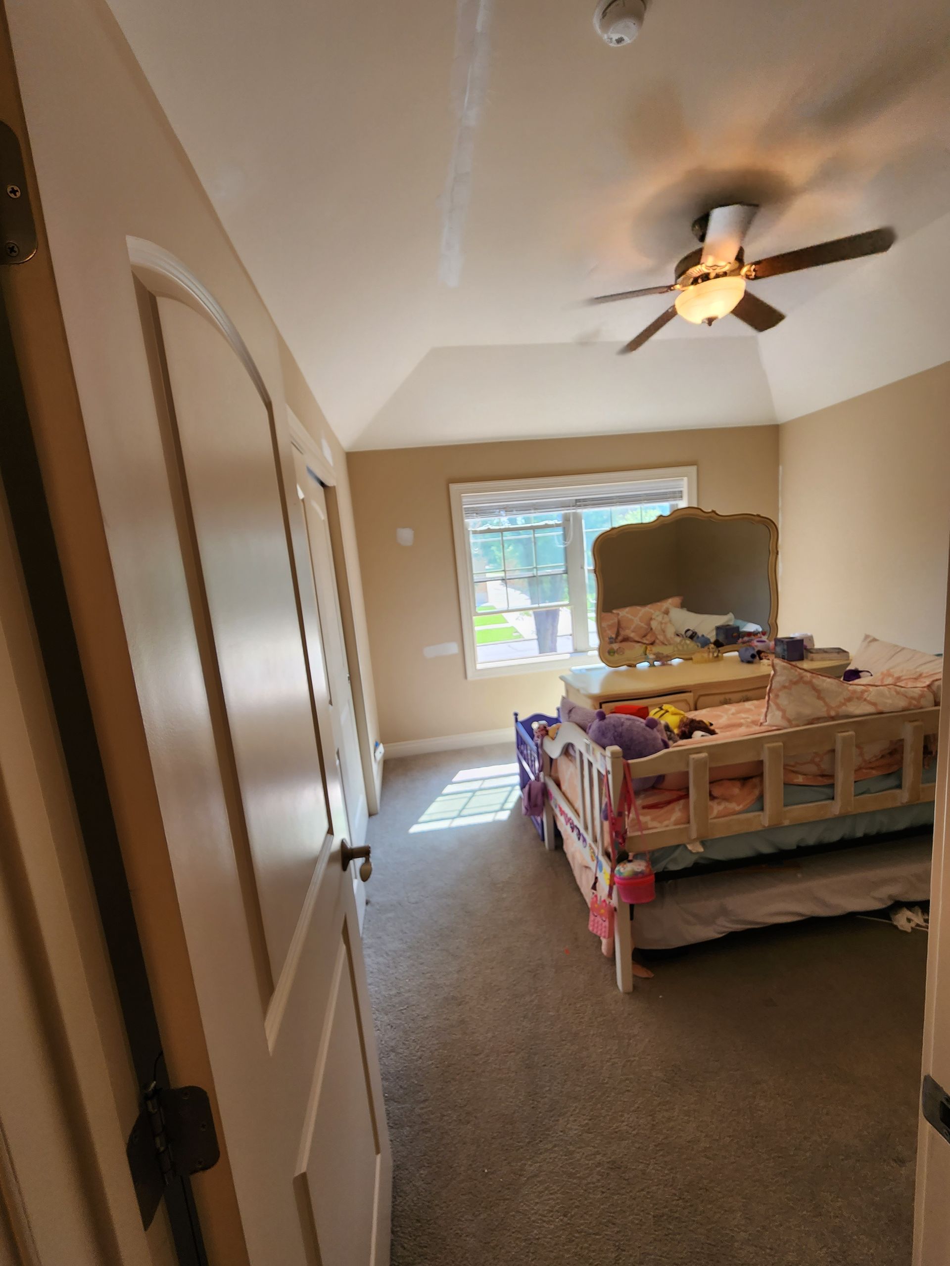 A bedroom with a bunk bed and a ceiling fan.