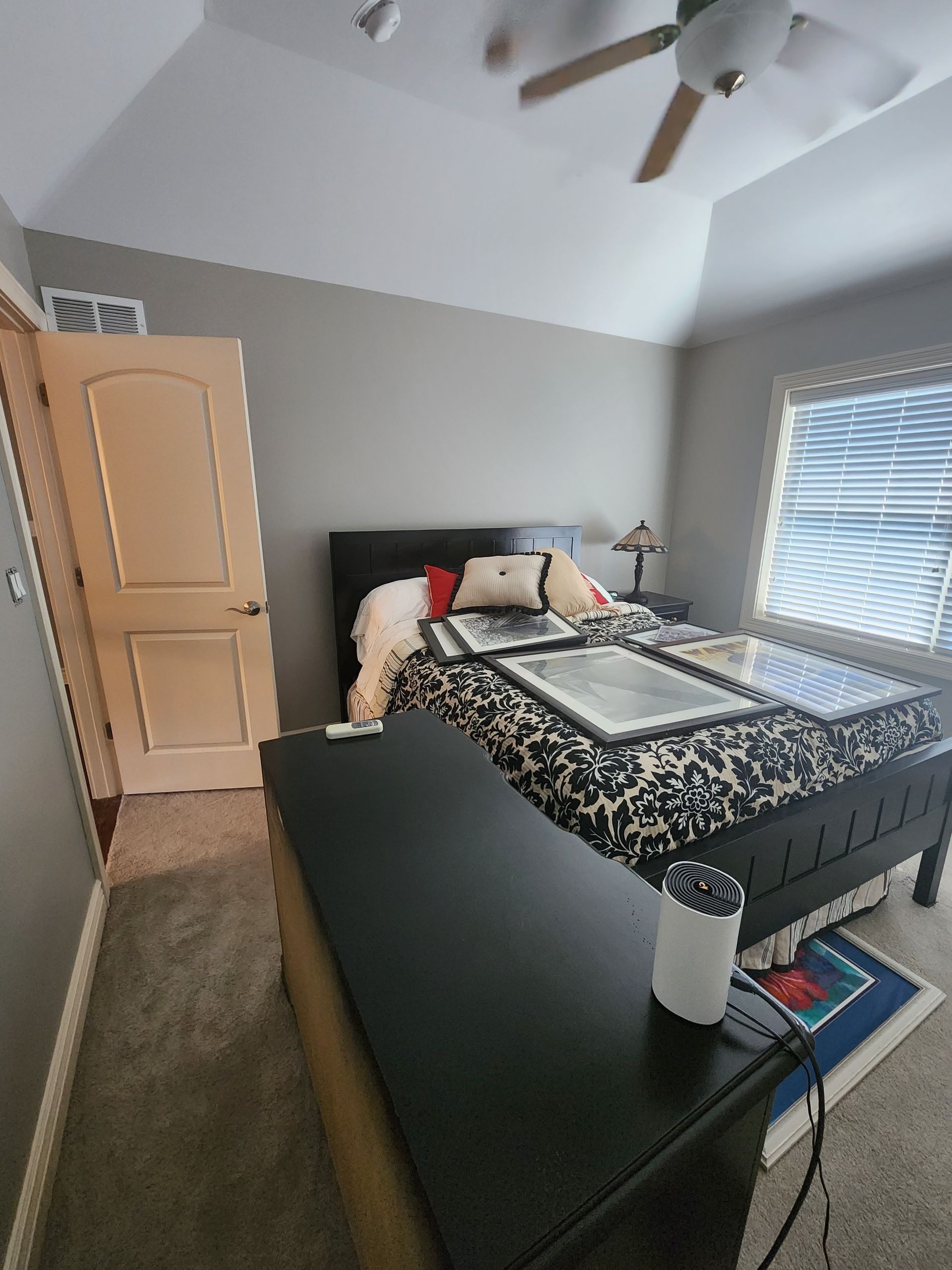 A bedroom with a king size bed and a ceiling fan