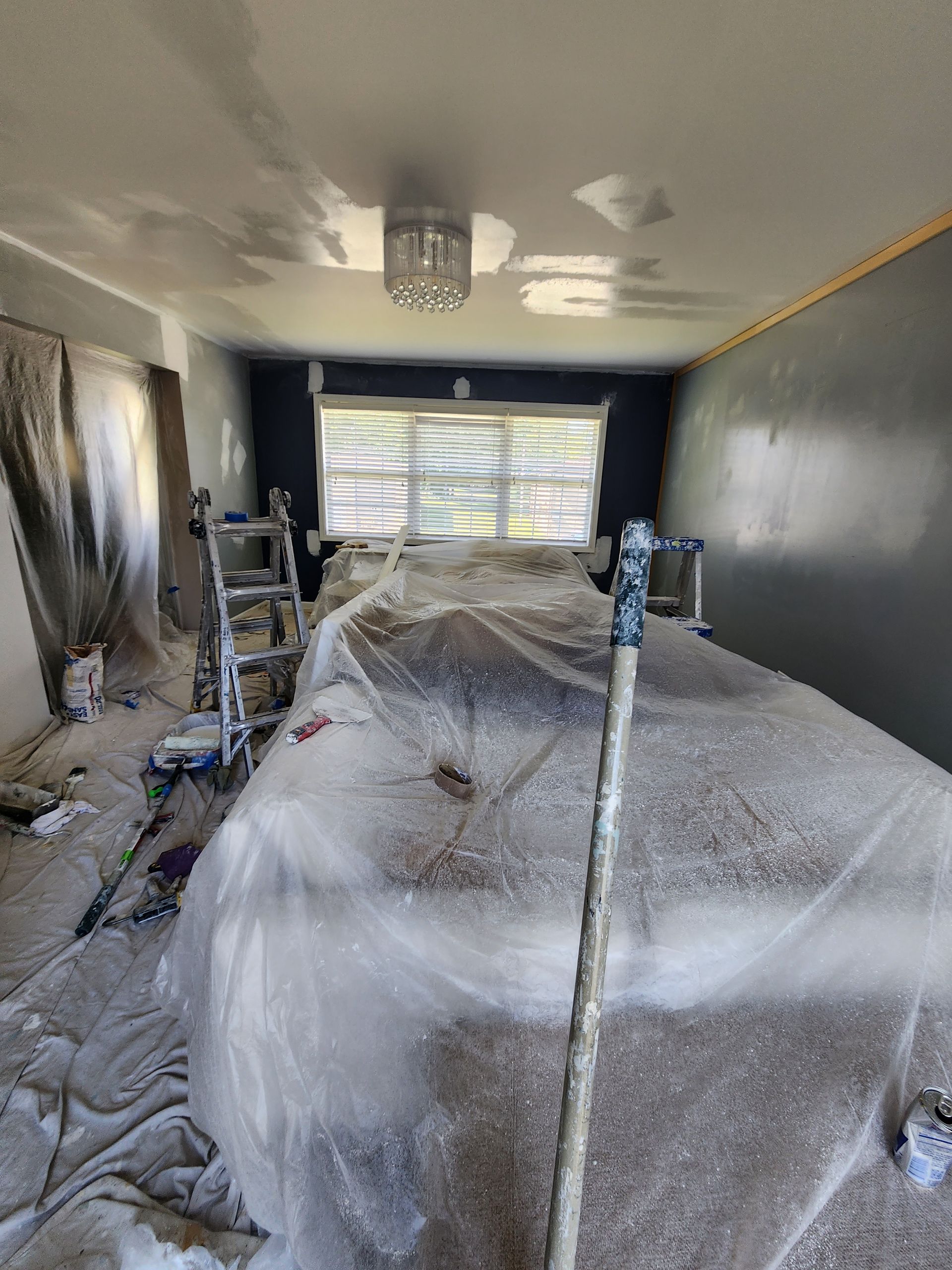 A room is being painted and covered in plastic.