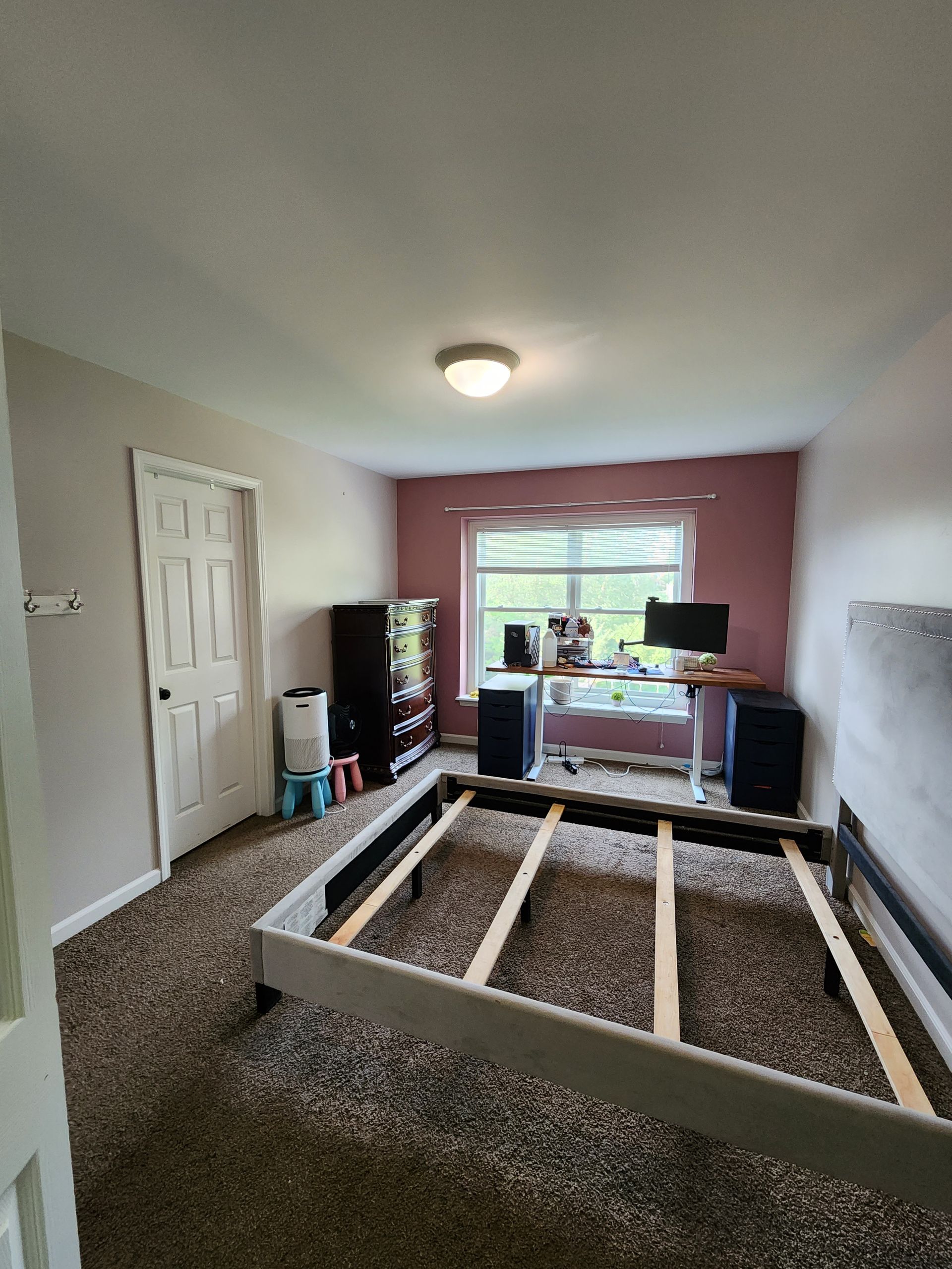 A bedroom with a bed and a desk in it.