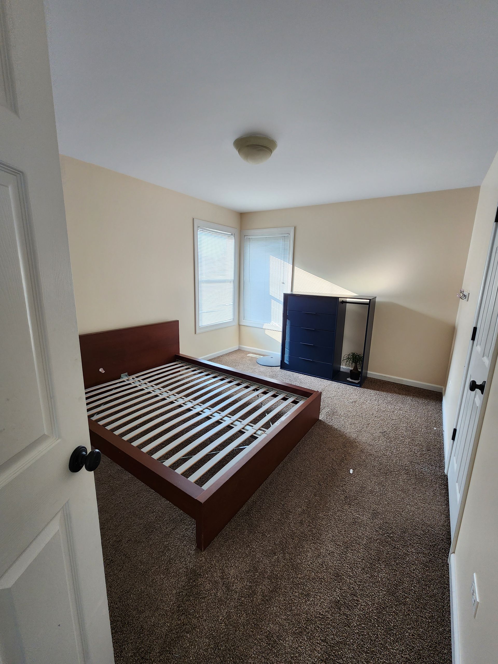 A bedroom with a bed and a dresser in it.