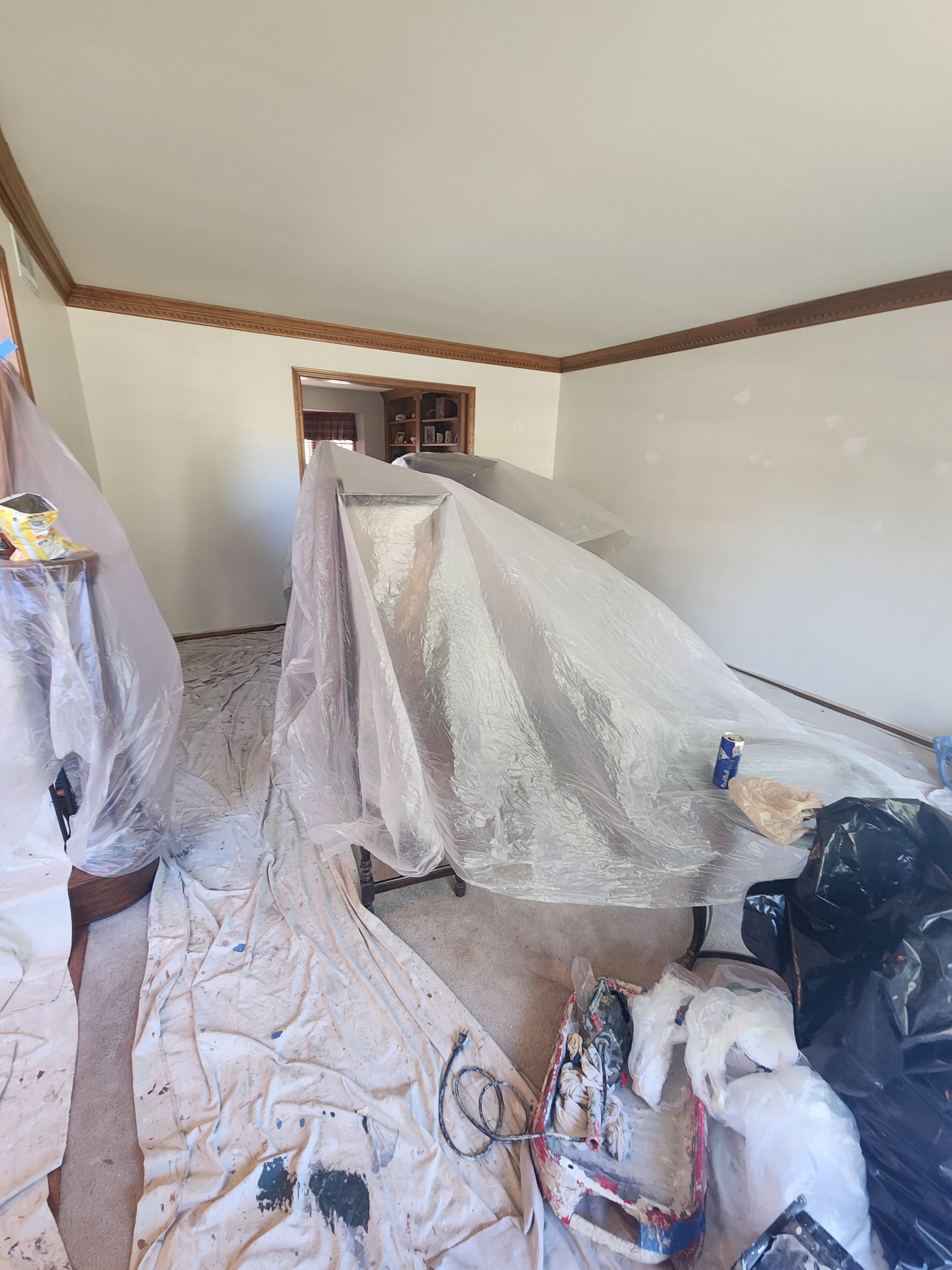 A room is being painted and covered in plastic.