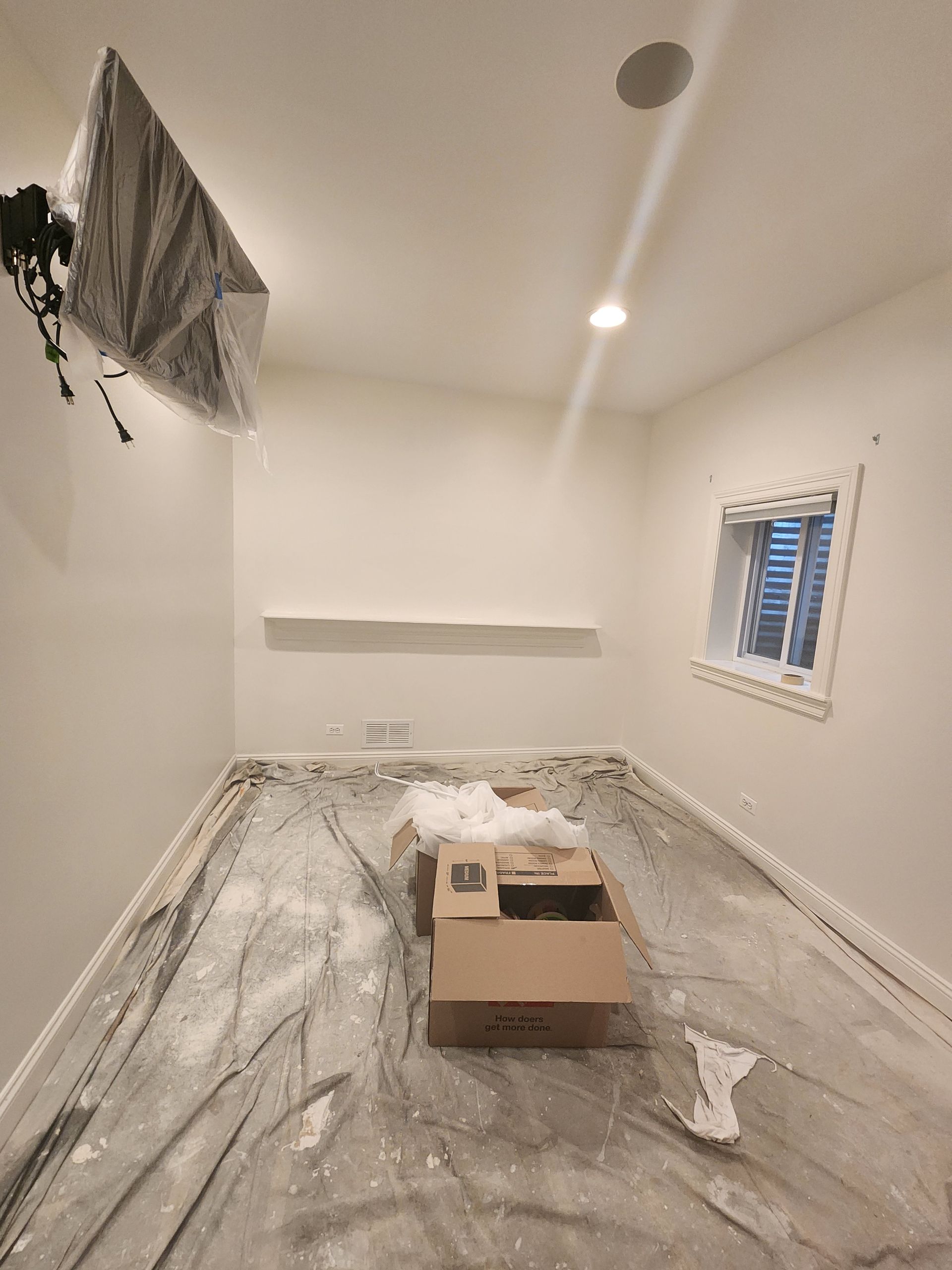 A room with a box on the floor and a window.