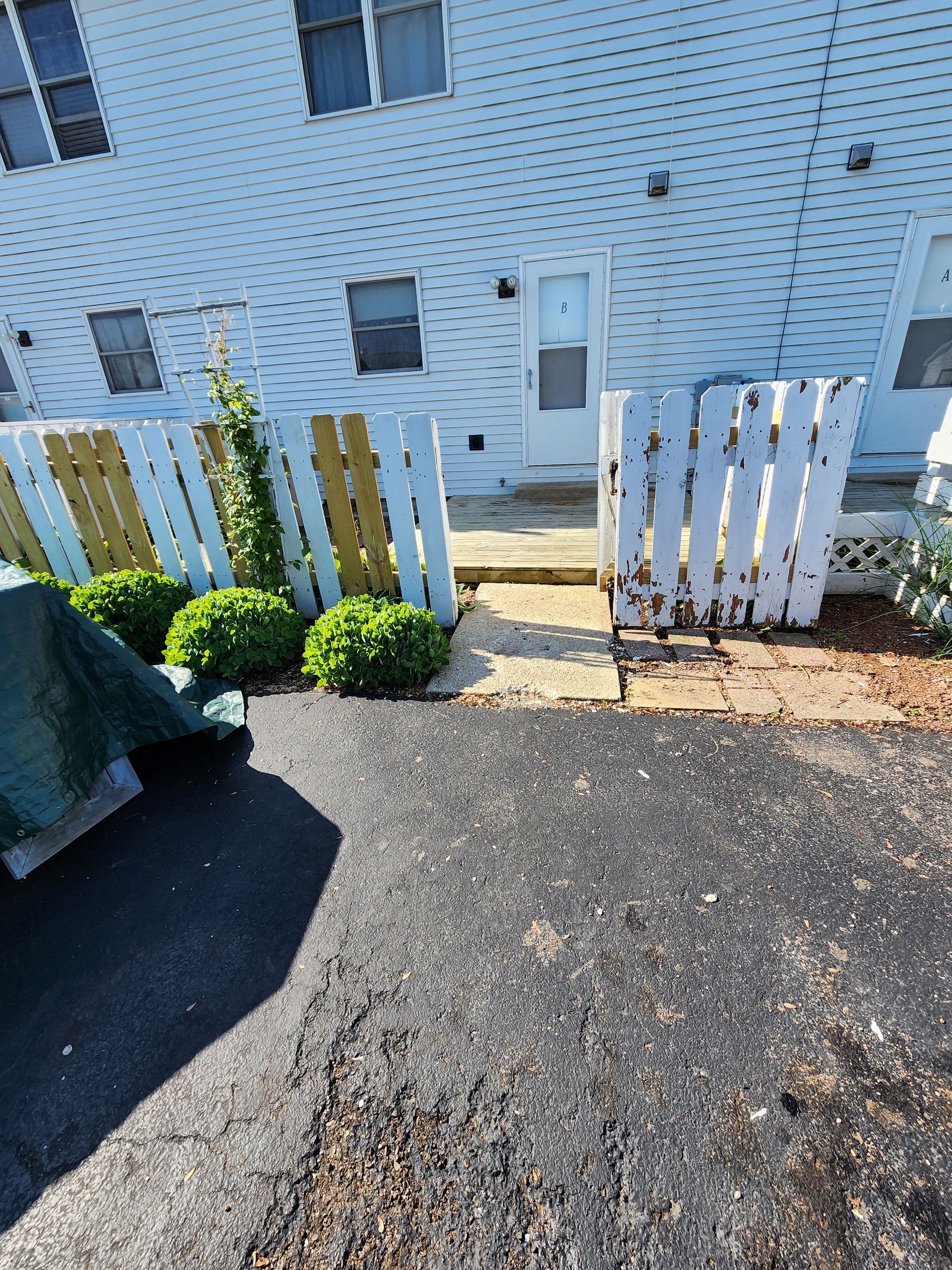 A white house with a wooden fence in front of it.