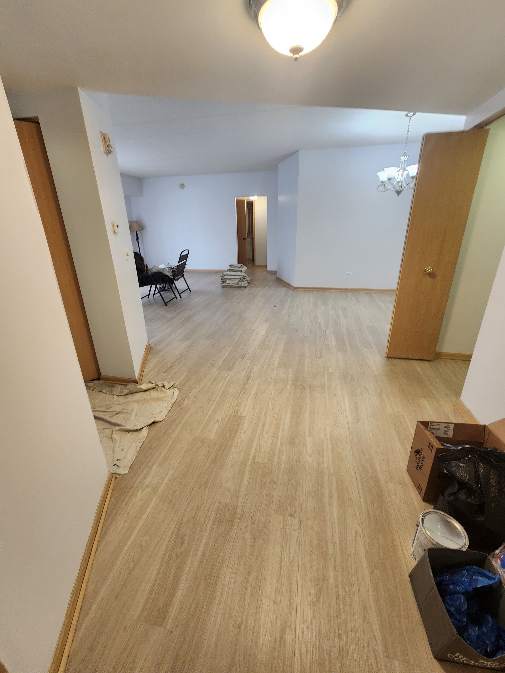 A large empty room with hardwood floors and white walls.