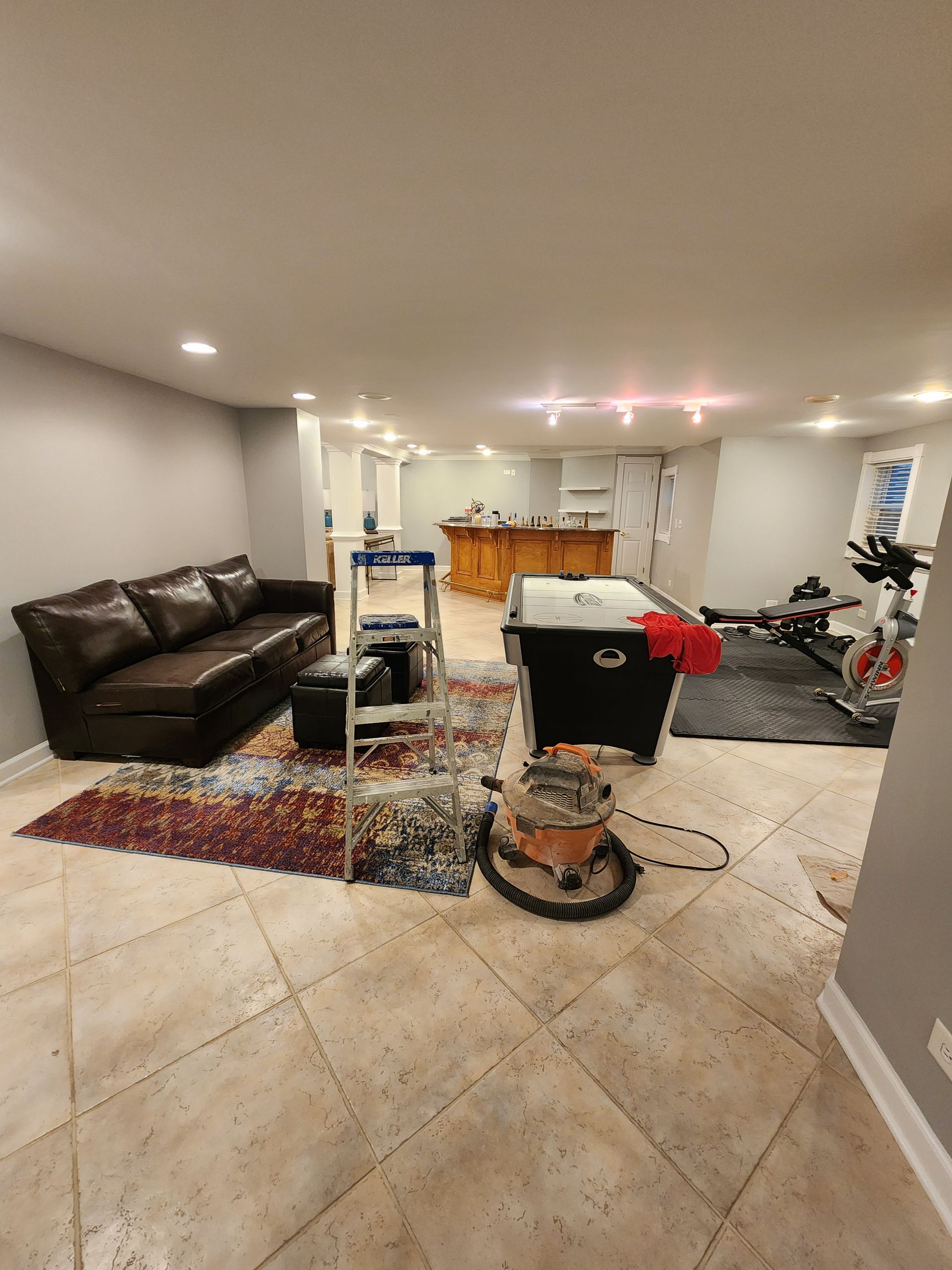 A living room with a pool table and a couch.