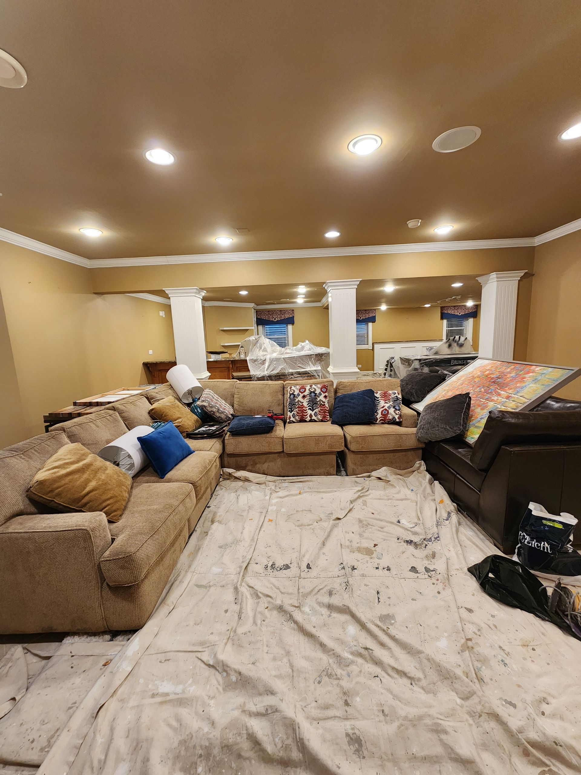 A living room with a lot of furniture and a white sheet on the floor.