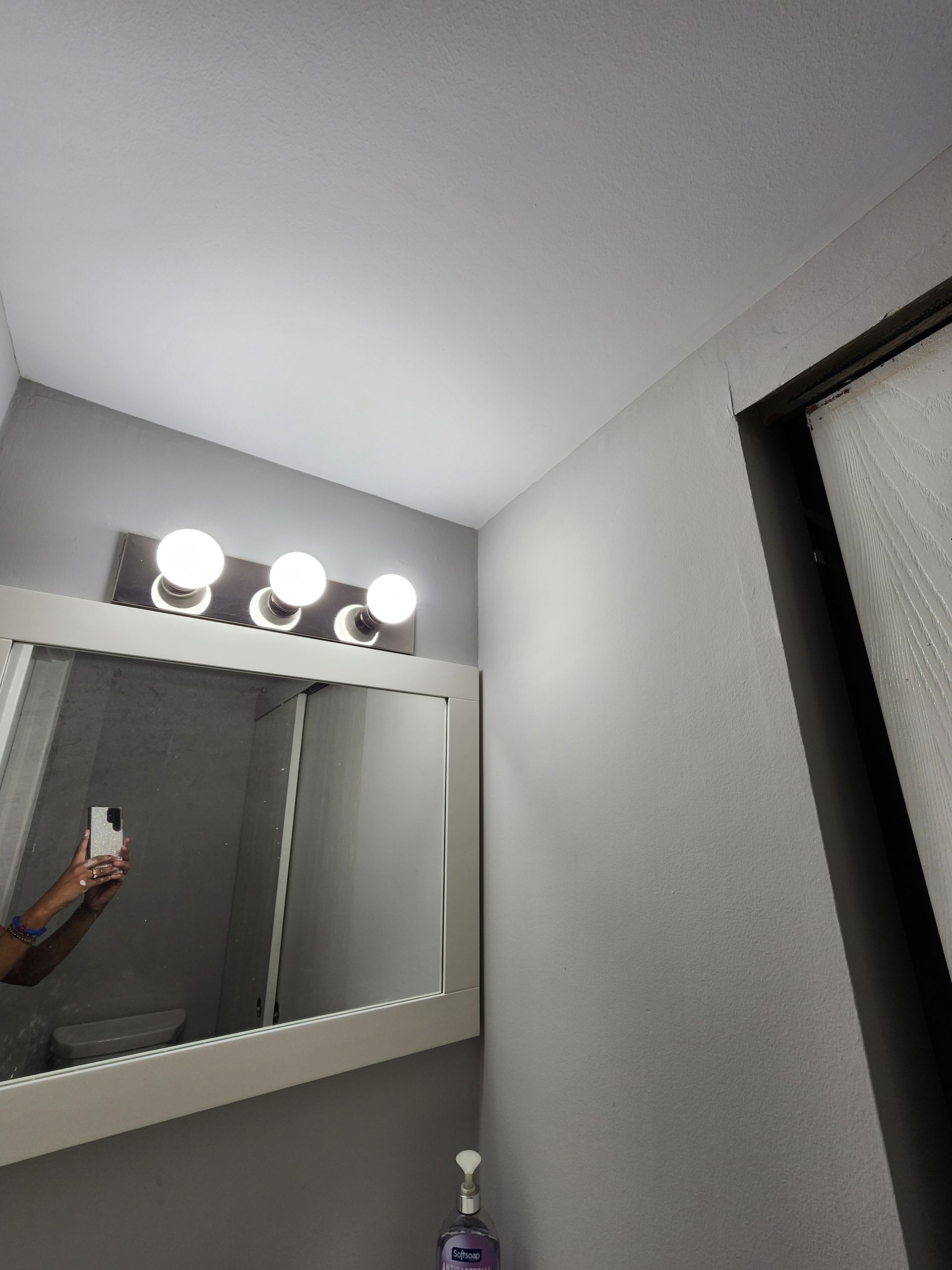 A person is taking a picture of themselves in a bathroom mirror.