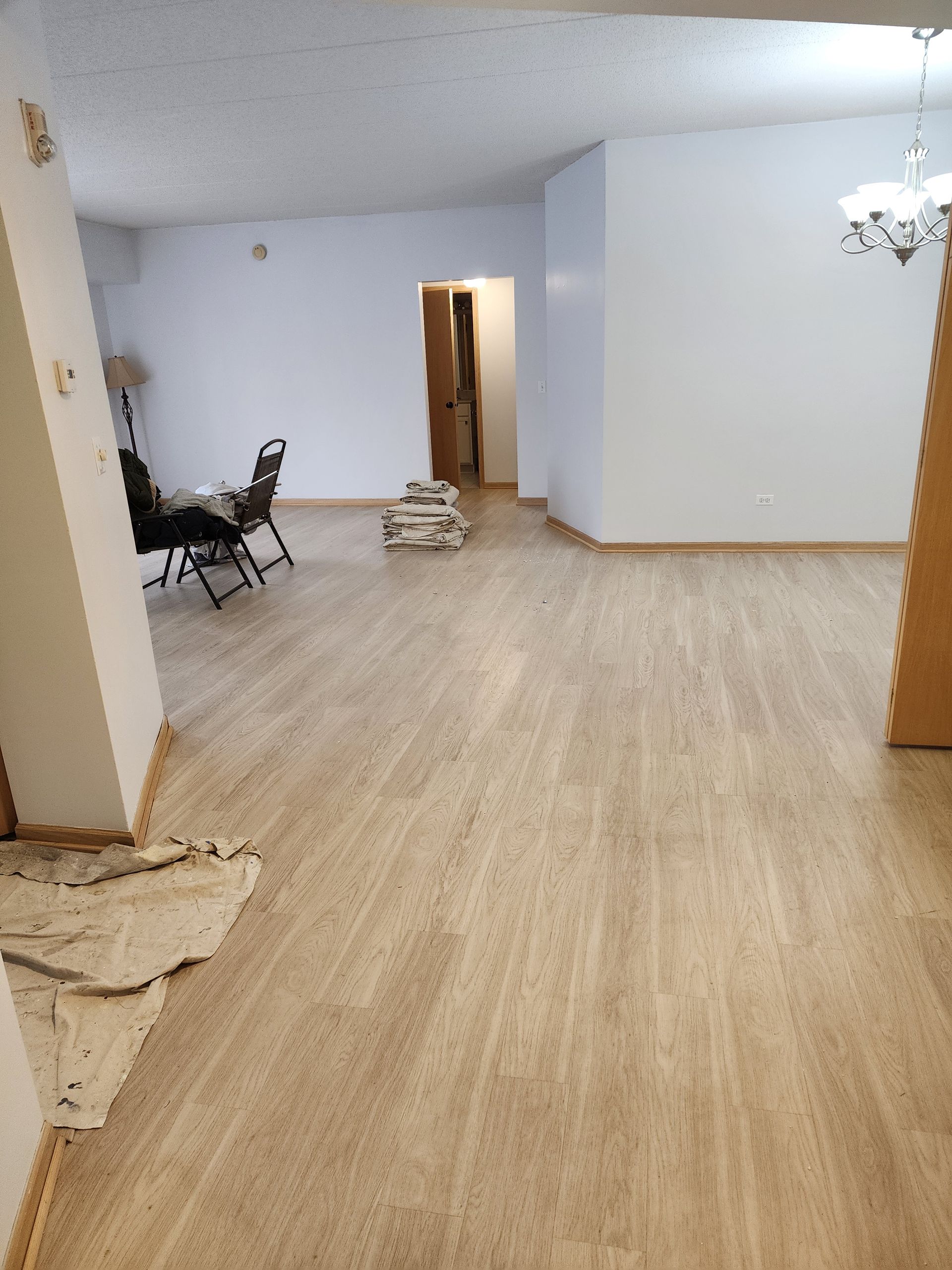 A large empty room with a wooden floor and white walls.