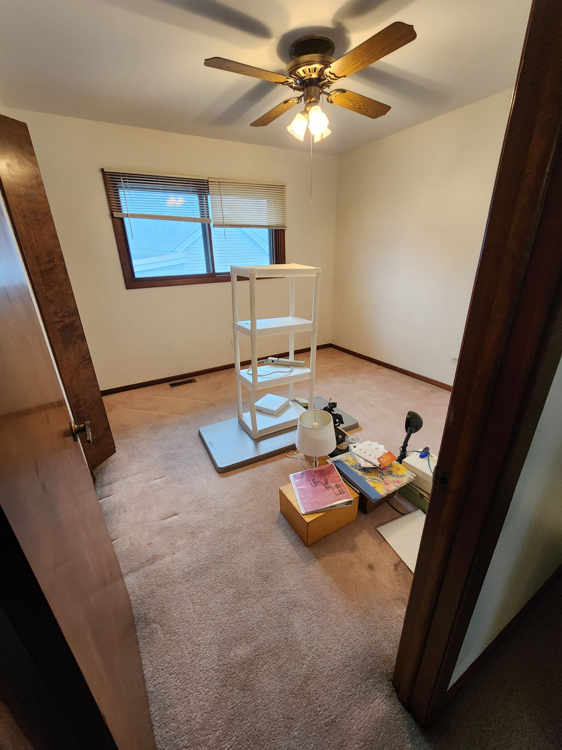 A room with a ceiling fan and a window