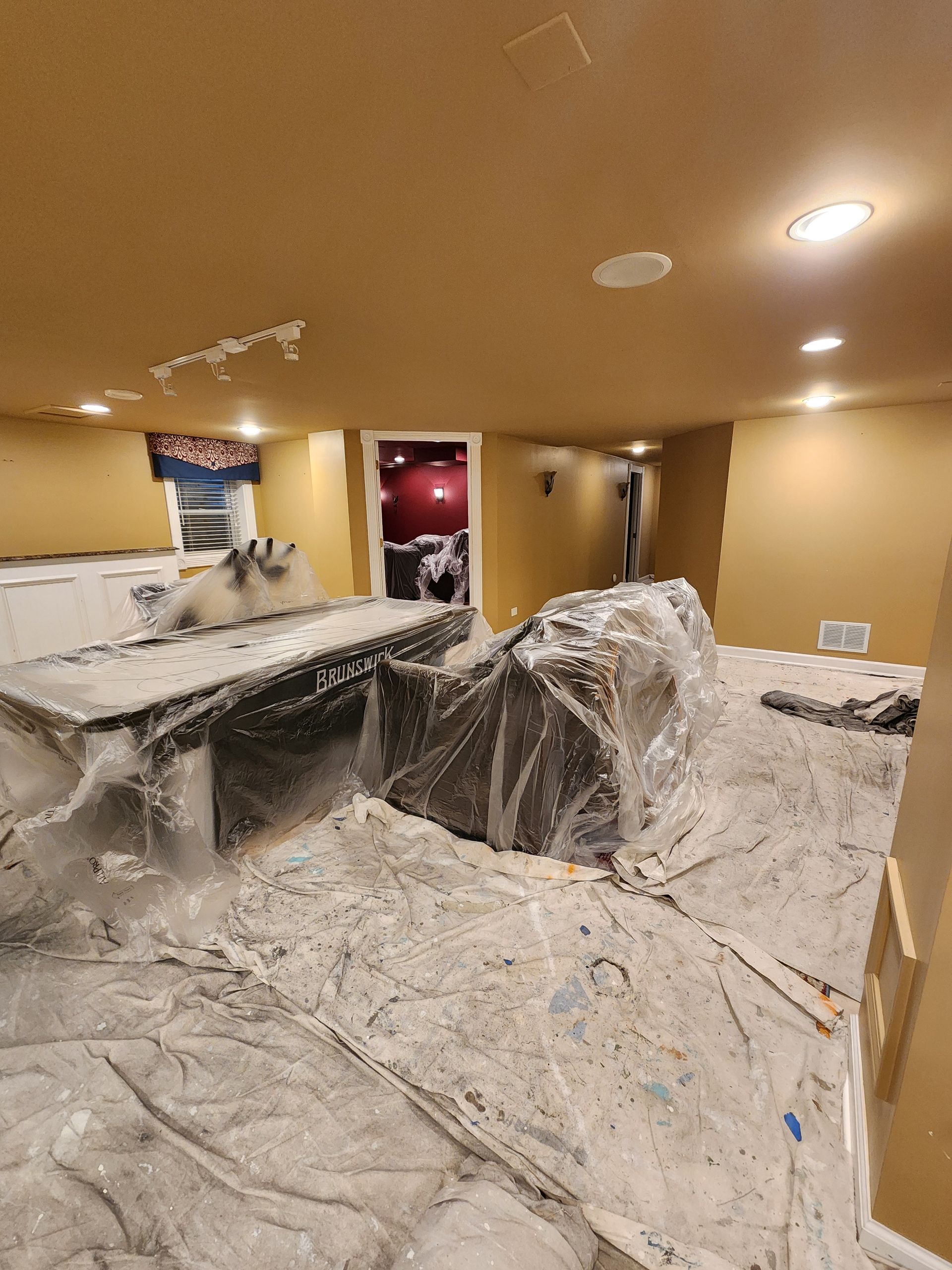 A room with a table and chairs covered in plastic wrap.