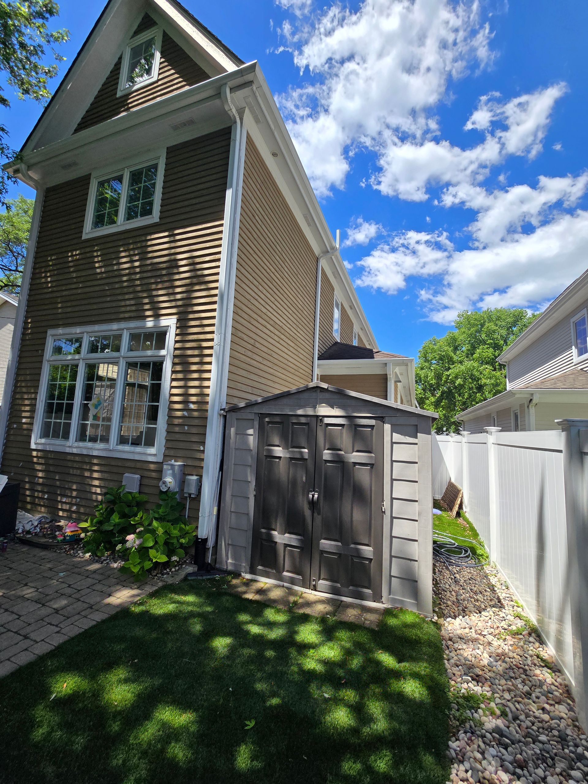 A brick house with a shed in front of it