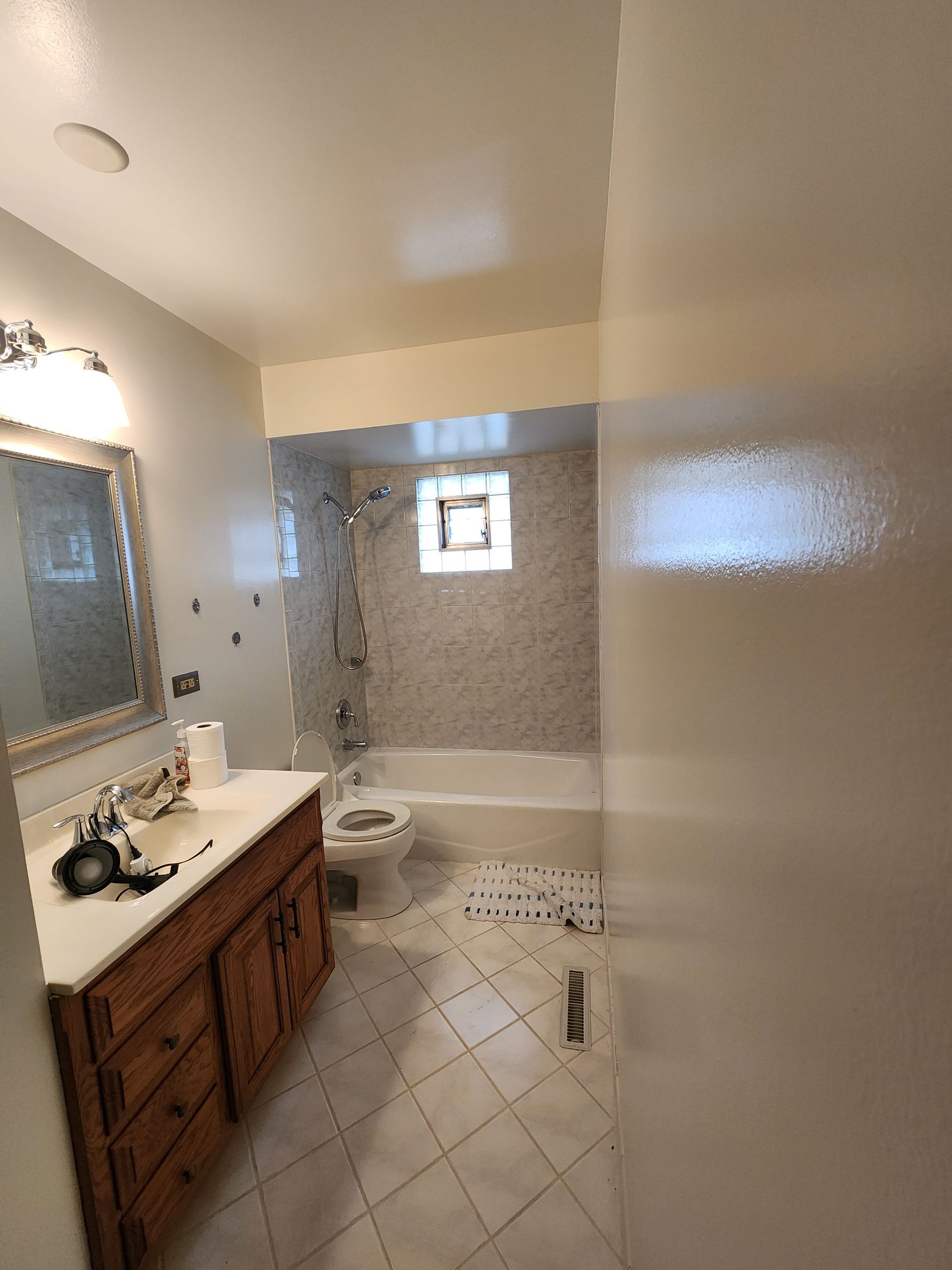 A bathroom with a sink , toilet , bathtub and mirror.