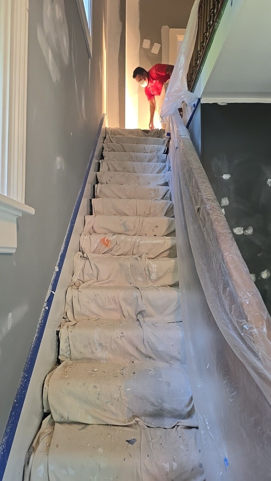 A man is standing on a set of stairs covered in plastic.