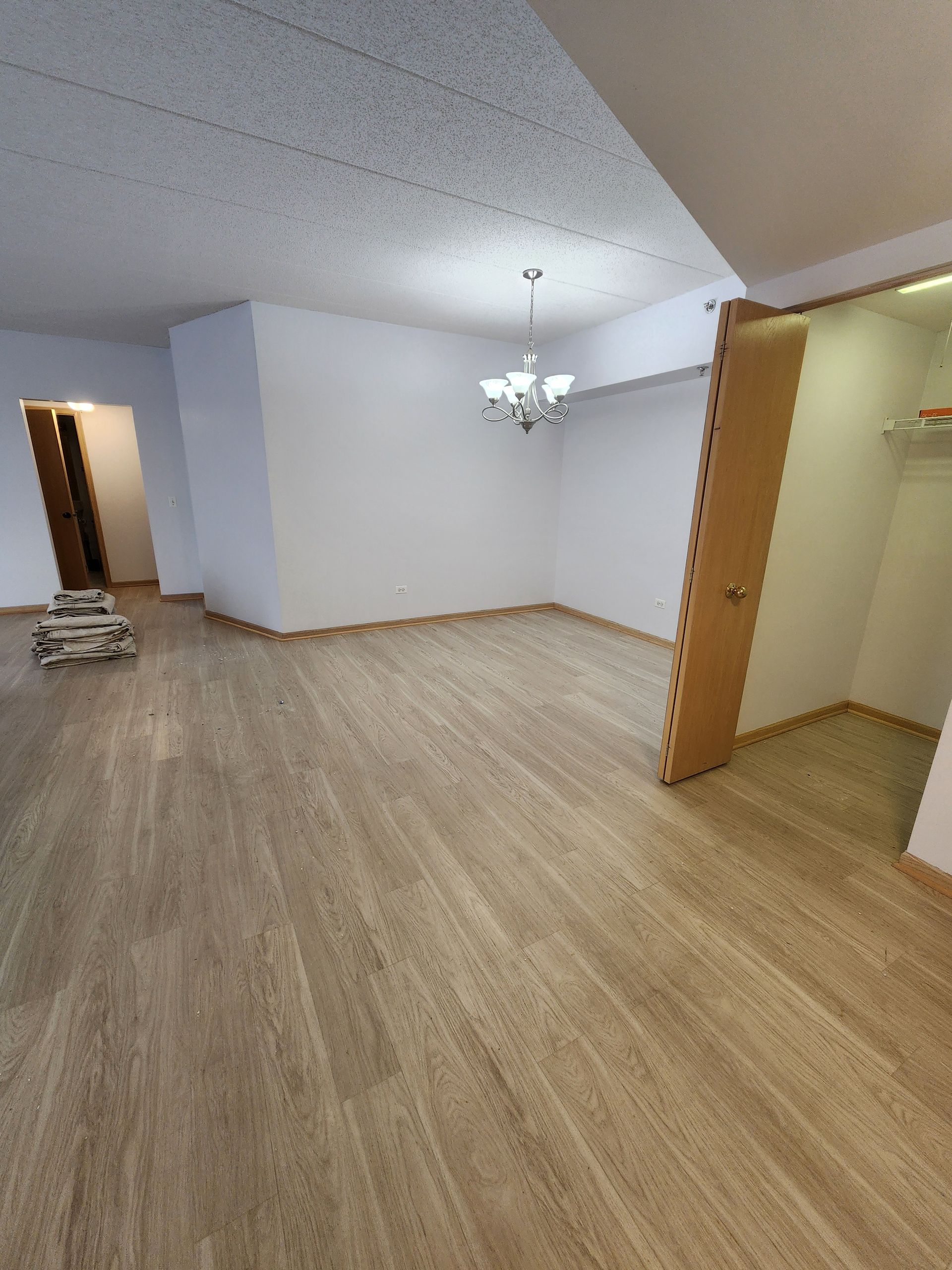 A living room with hardwood floors and a chandelier.