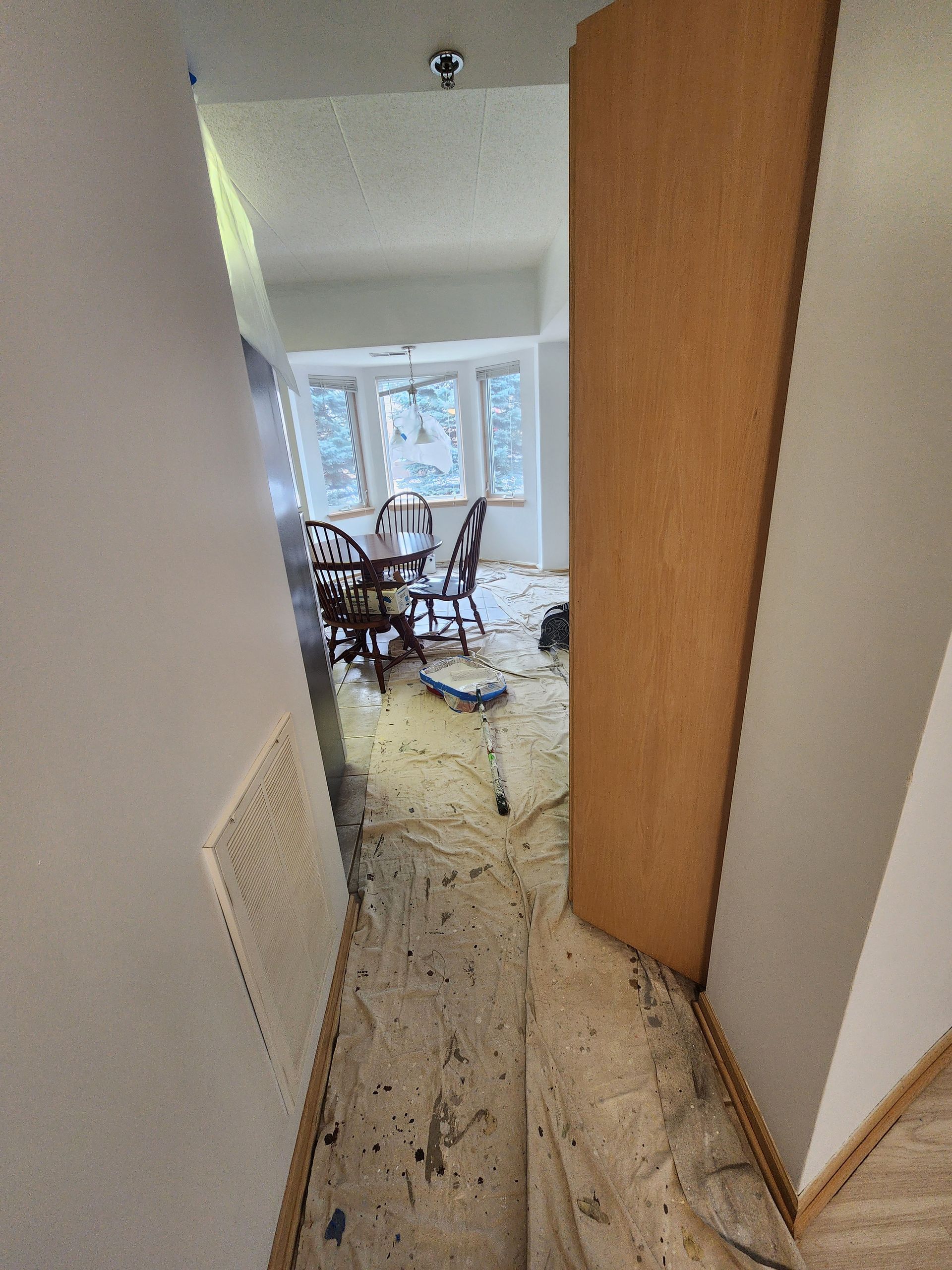 A hallway leading to a dining room with a table and chairs.