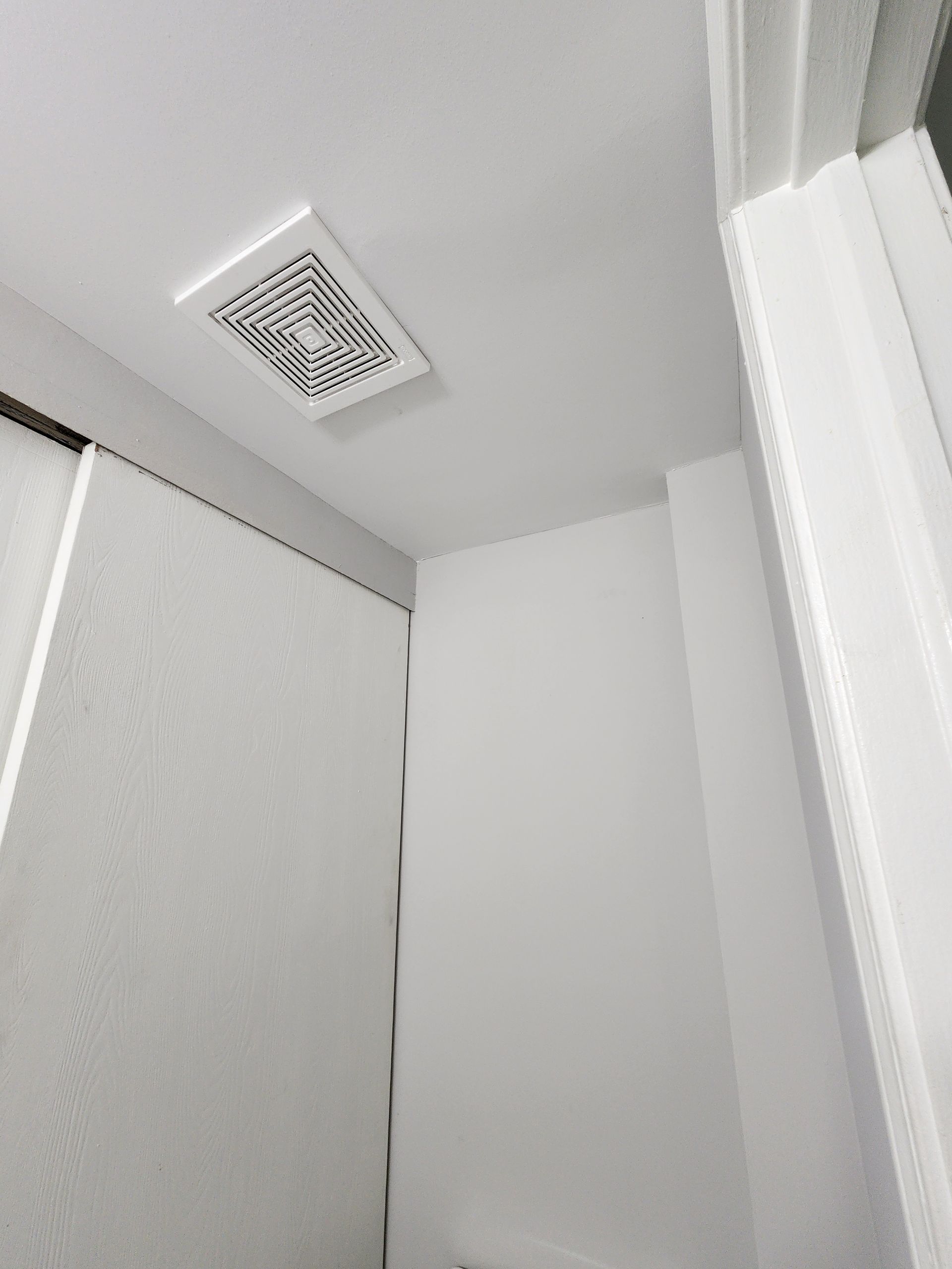 A bathroom with a fan hanging from the ceiling.