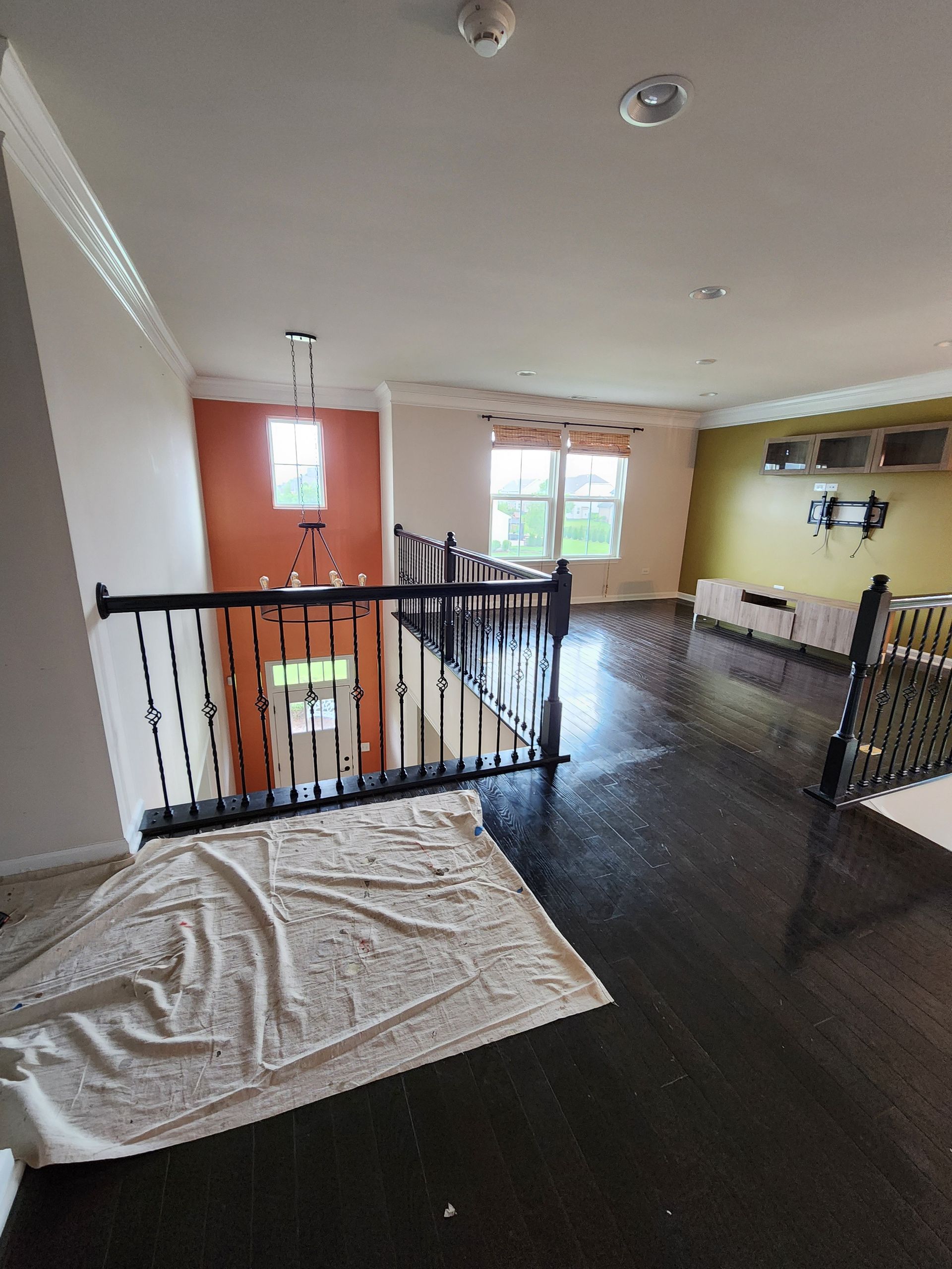 A living room with a staircase and a rug on the floor.