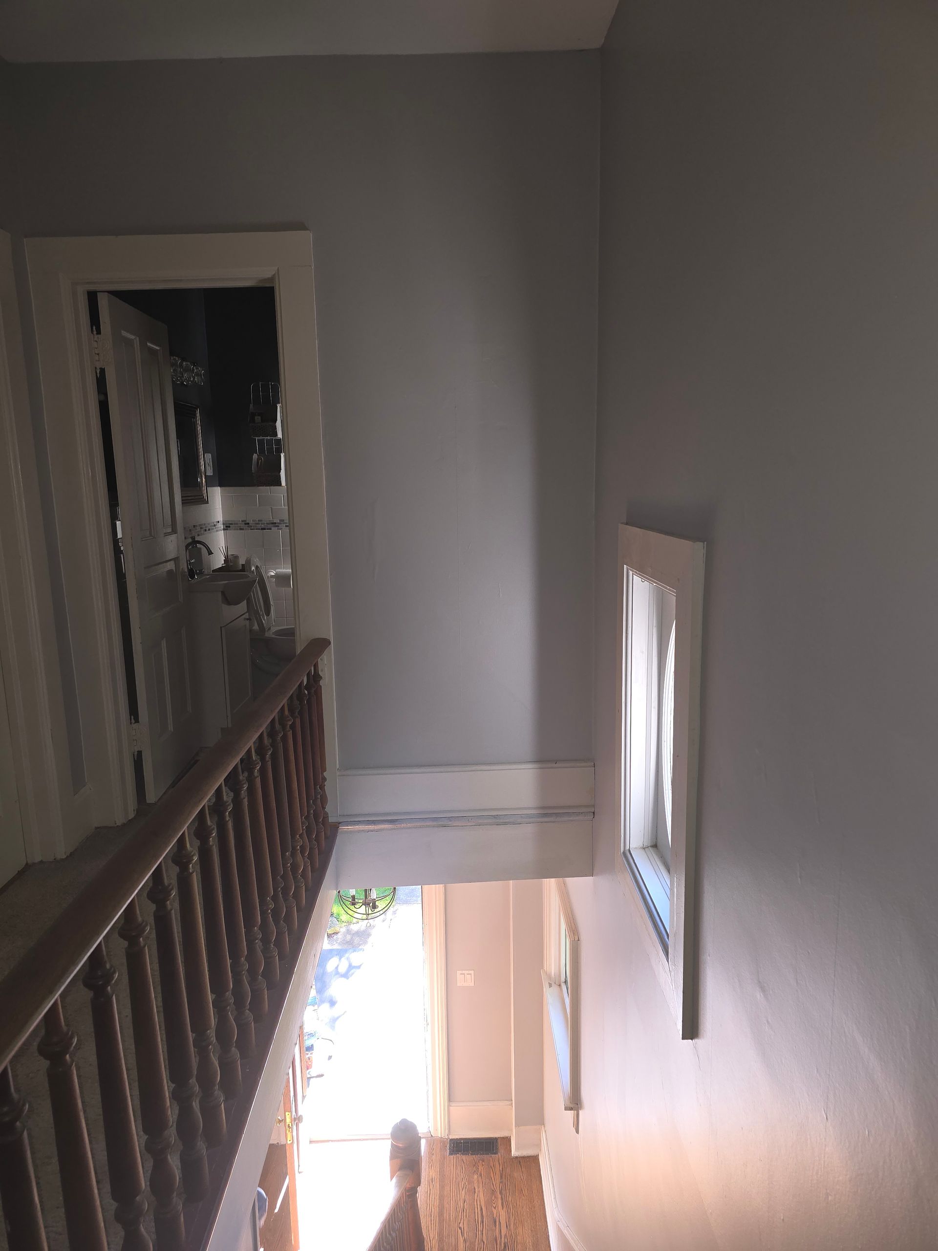 A person is walking down a set of stairs in a house.