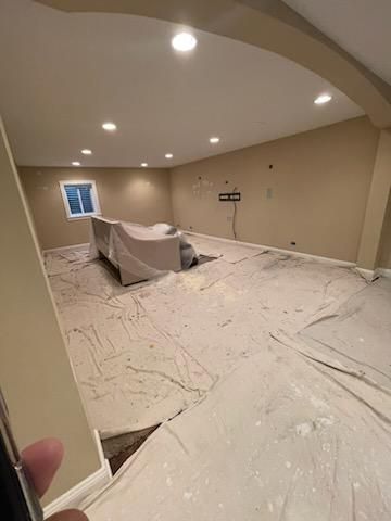 A living room with a couch and a tv on the floor.