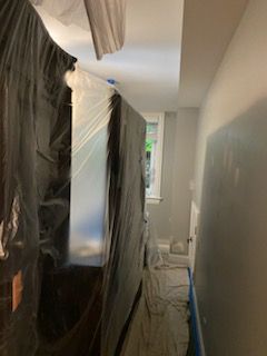 A room is being painted and covered in plastic.