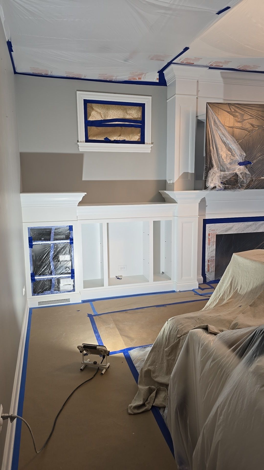 A living room is being painted in a house.