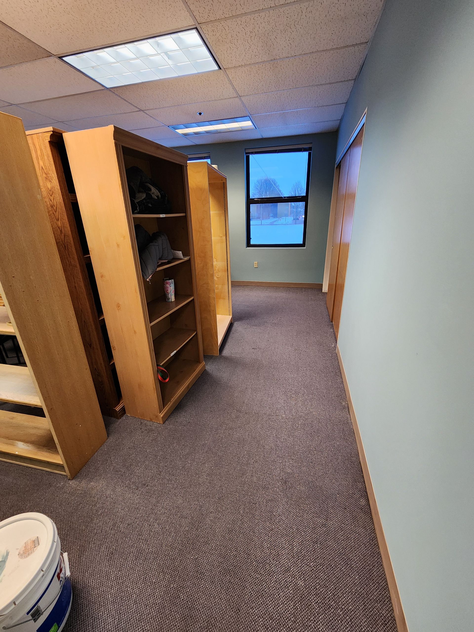 A hallway with shelves and a window in a building