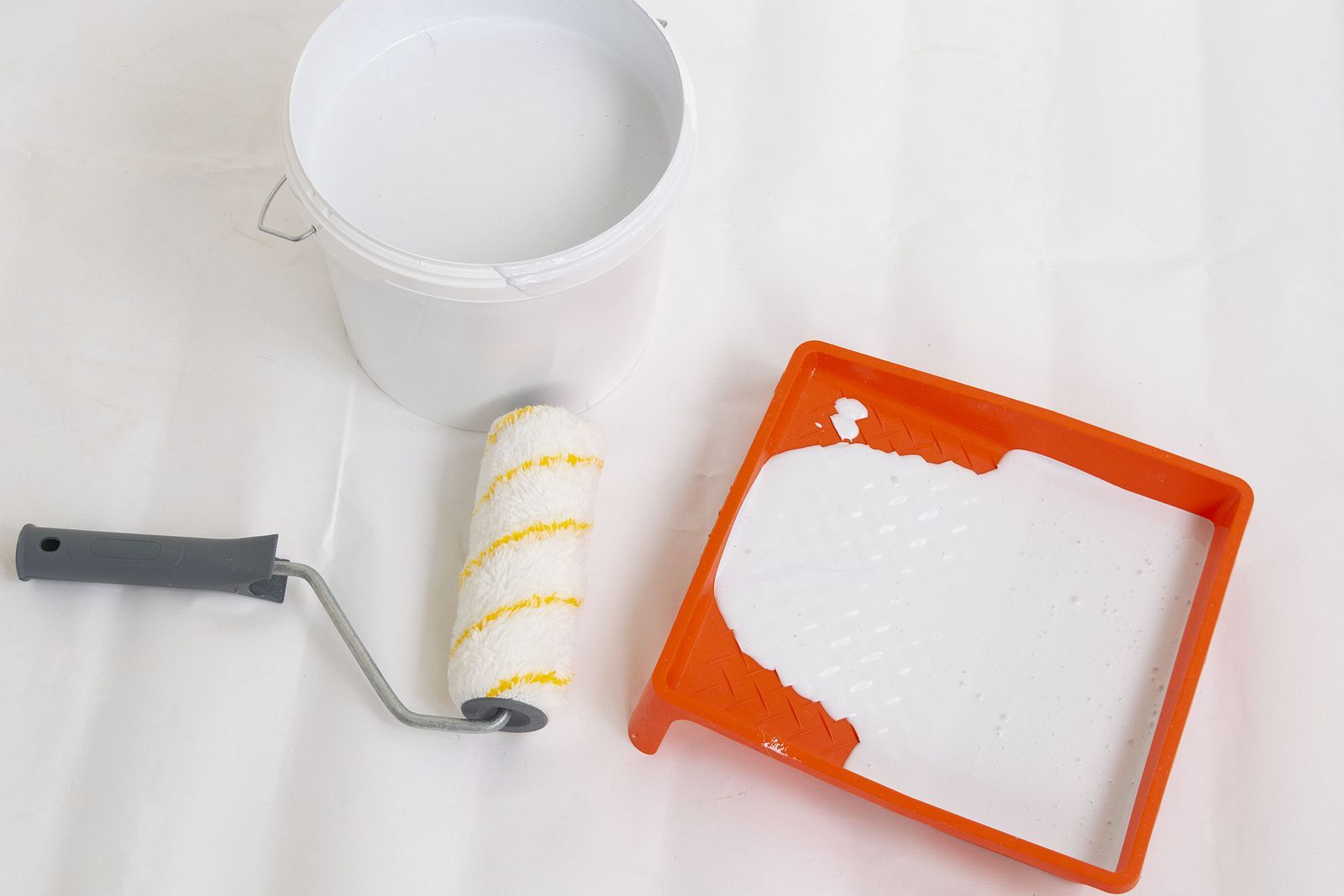 paint roller on floor next to tray
