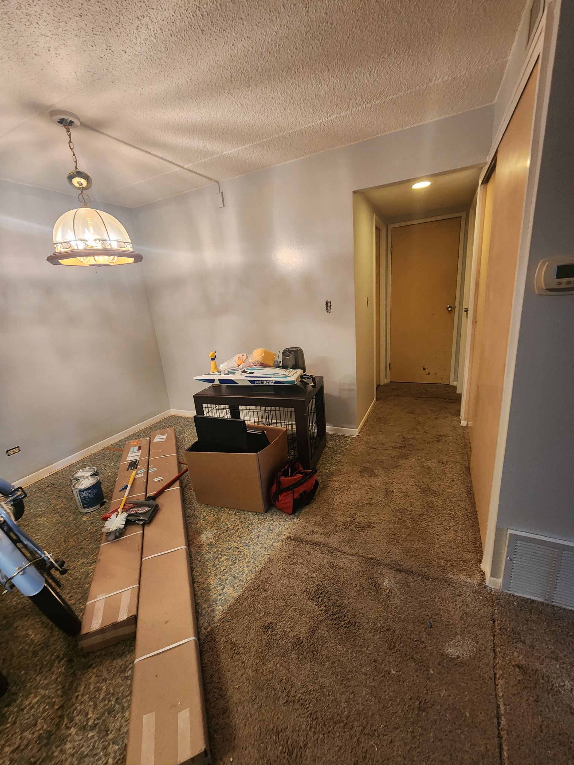 A living room with a table and a box on the floor.