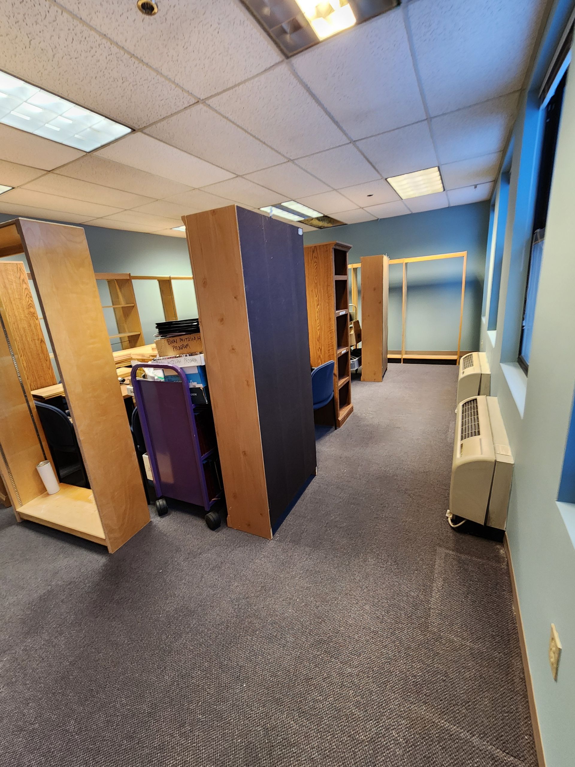 A large room with a lot of shelves and a window.