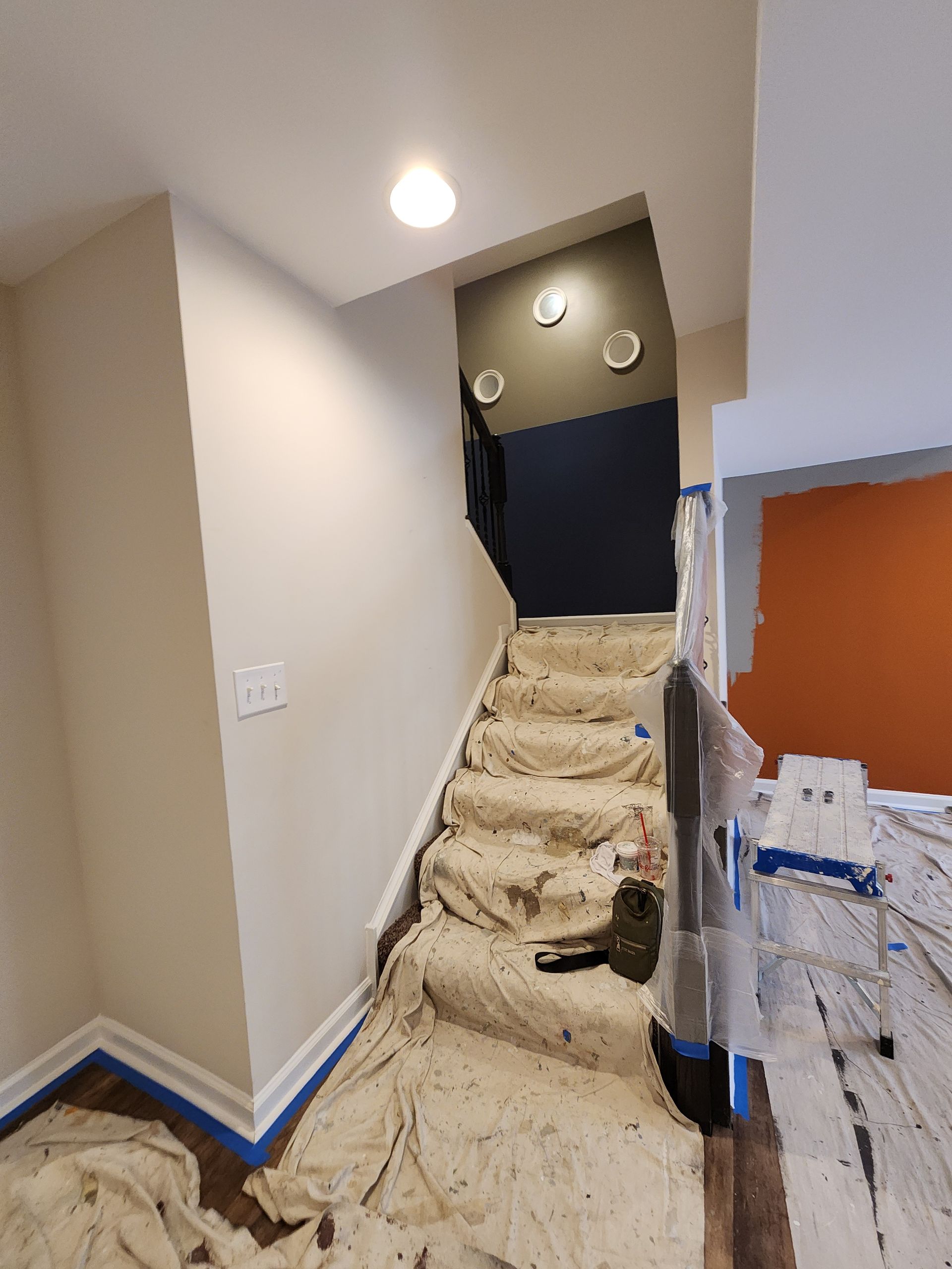 A staircase is being painted in a house.